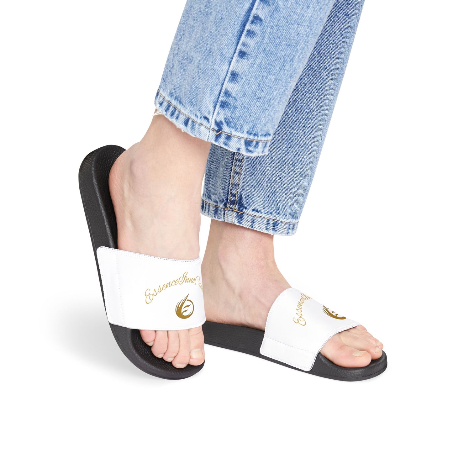 Person wearing black slides with white straps featuring 'EssenceInnoCreate' on a white background