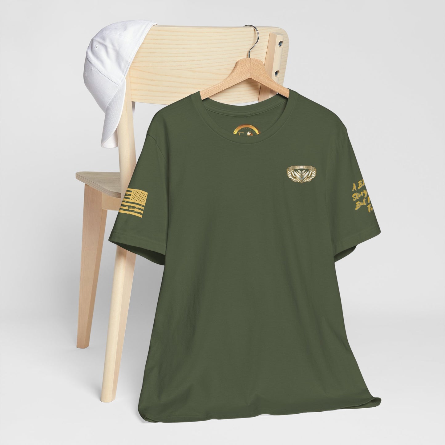 Green t-shirt with gold designs on a wooden chair against a white background