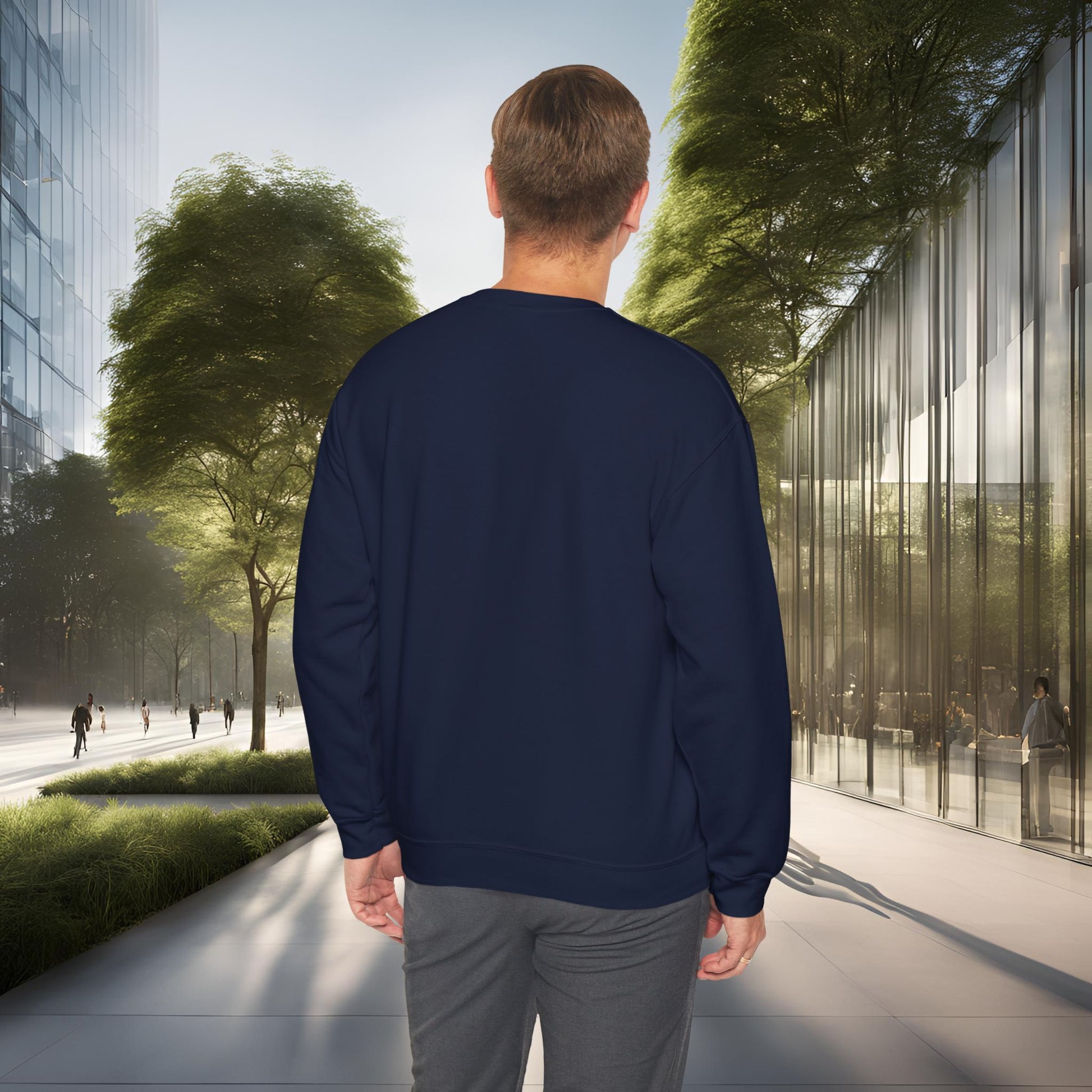 Man wearing a navy blue 'EssenceInnoCreate' sweatshirt walking on a city street with modern buildings and trees.