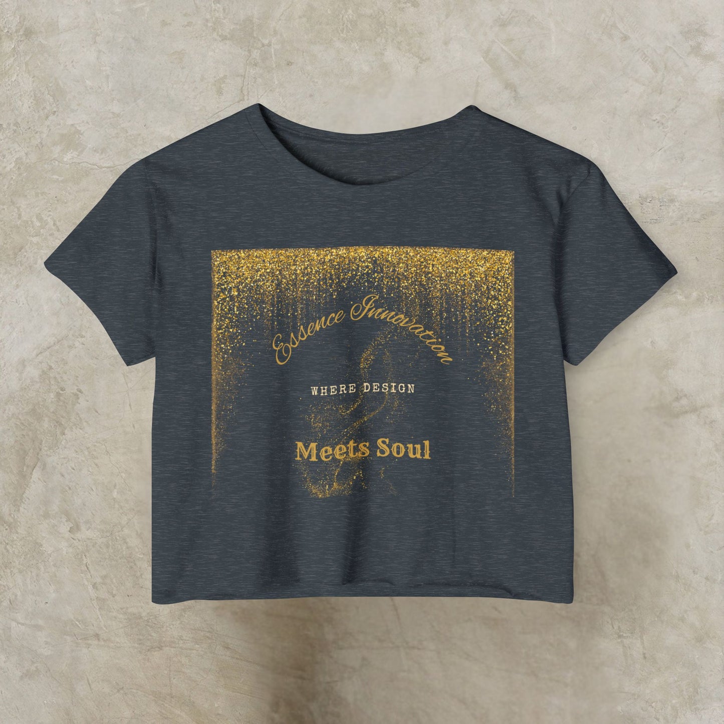Dark gray t-shirt with gold Essence Innovation 'Design Meets Soul' text and design on a beige background