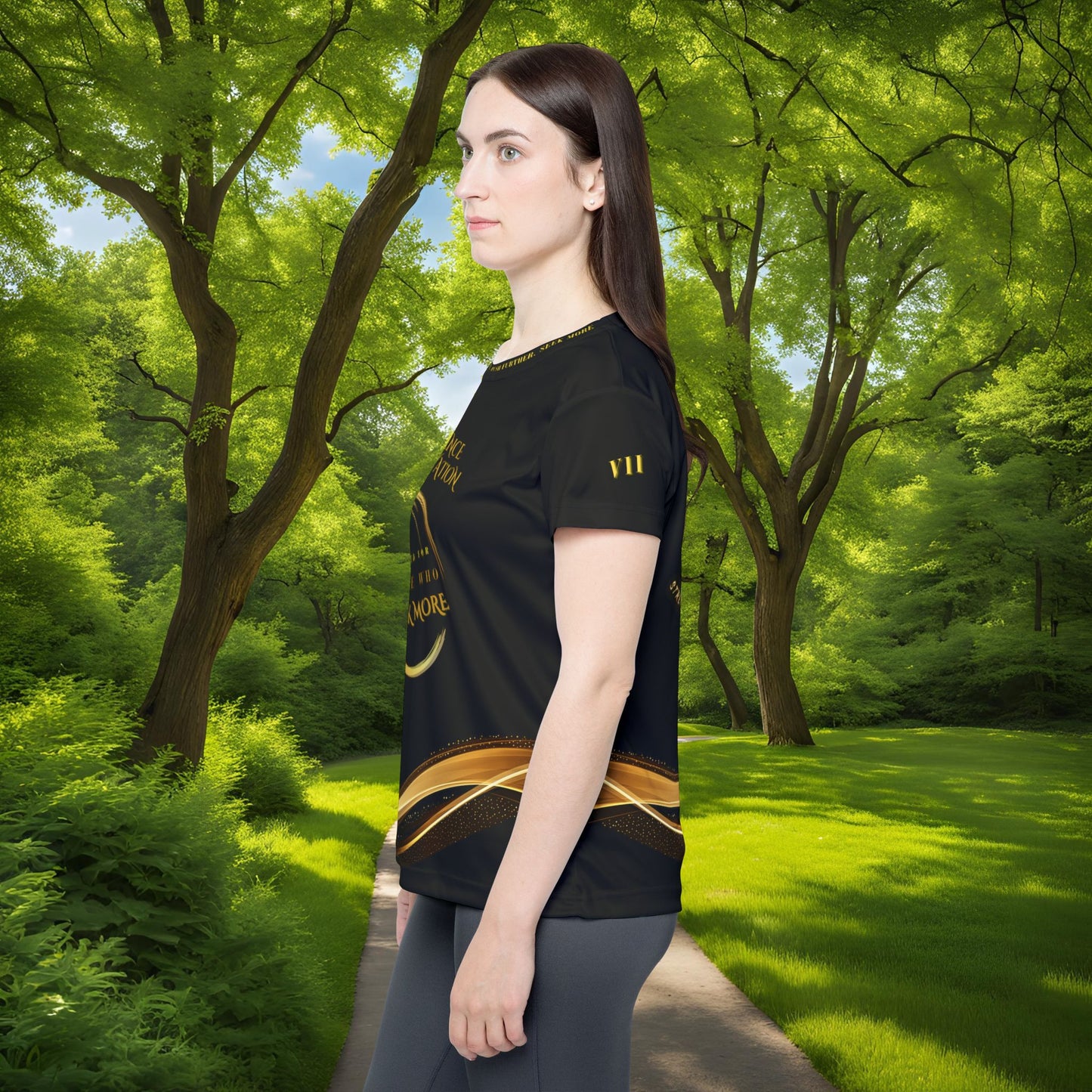 Woman wearing a black t-shirt with gold design in a forest setting