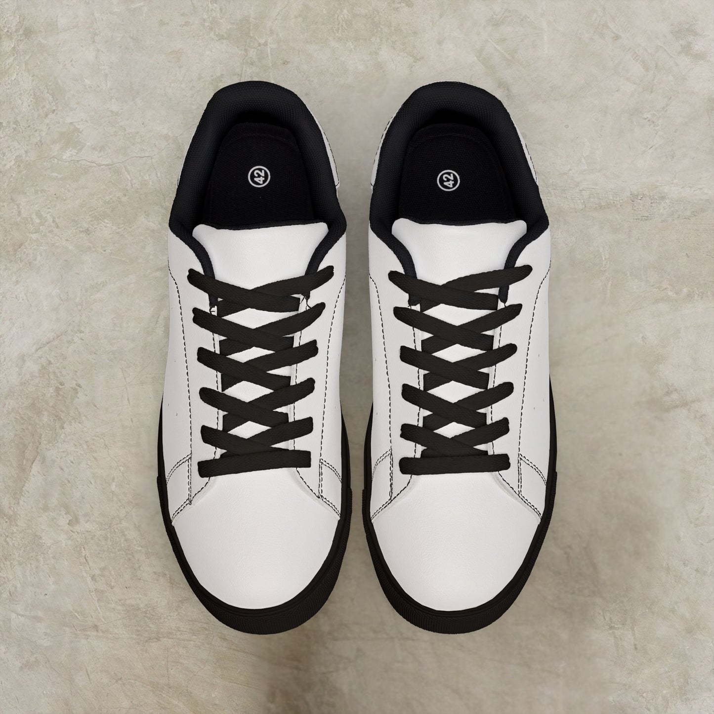White EssenceInnoCreate sneakers with black soles on a beige surface