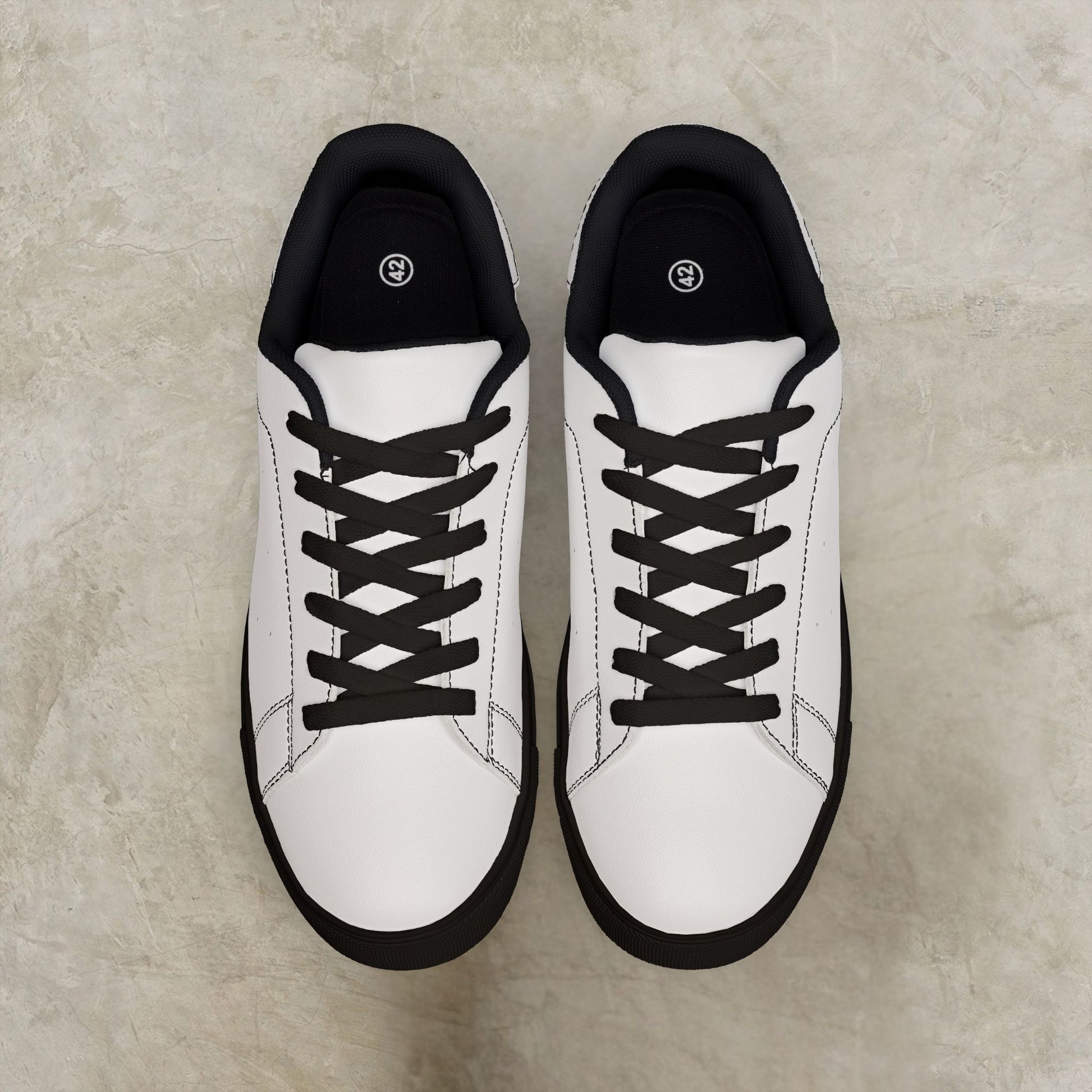 White EssenceInnoCreate sneakers with black soles on a beige surface