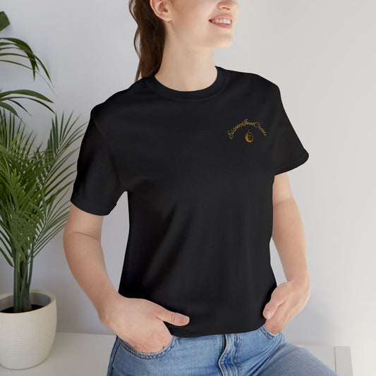 Person wearing a black t-shirt with 'EssenceInnoCreate' logo standing indoors with a plant in the background.
