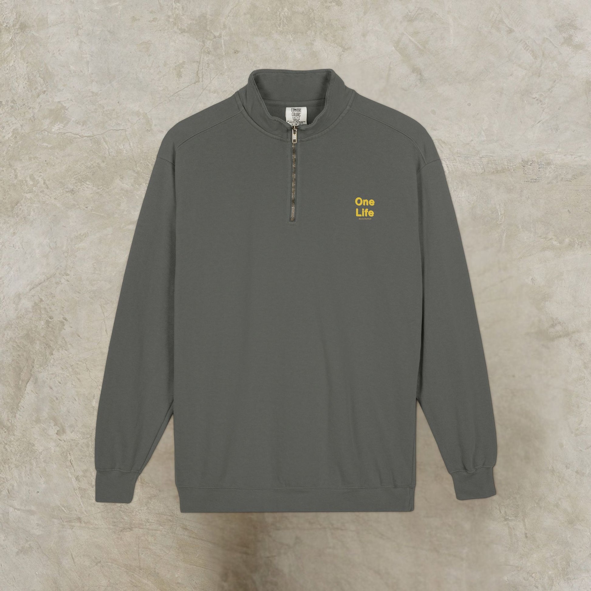 Gray sweatshirt with 'One Life' text on a beige background