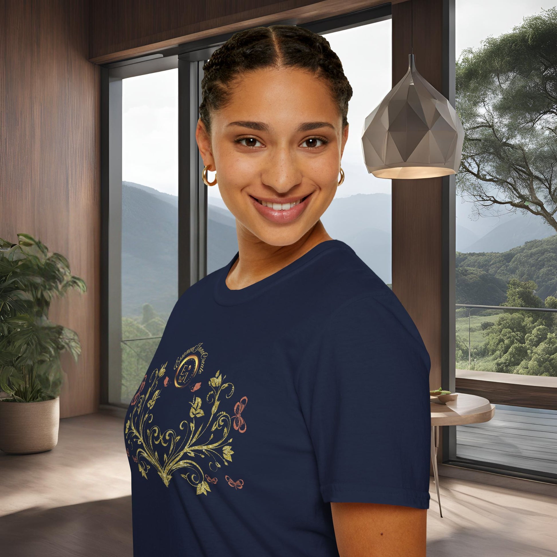Woman wearing a navy blue t-shirt with a Essence Innovation Bohemian Butterfly floral design in a modern room with large windows.