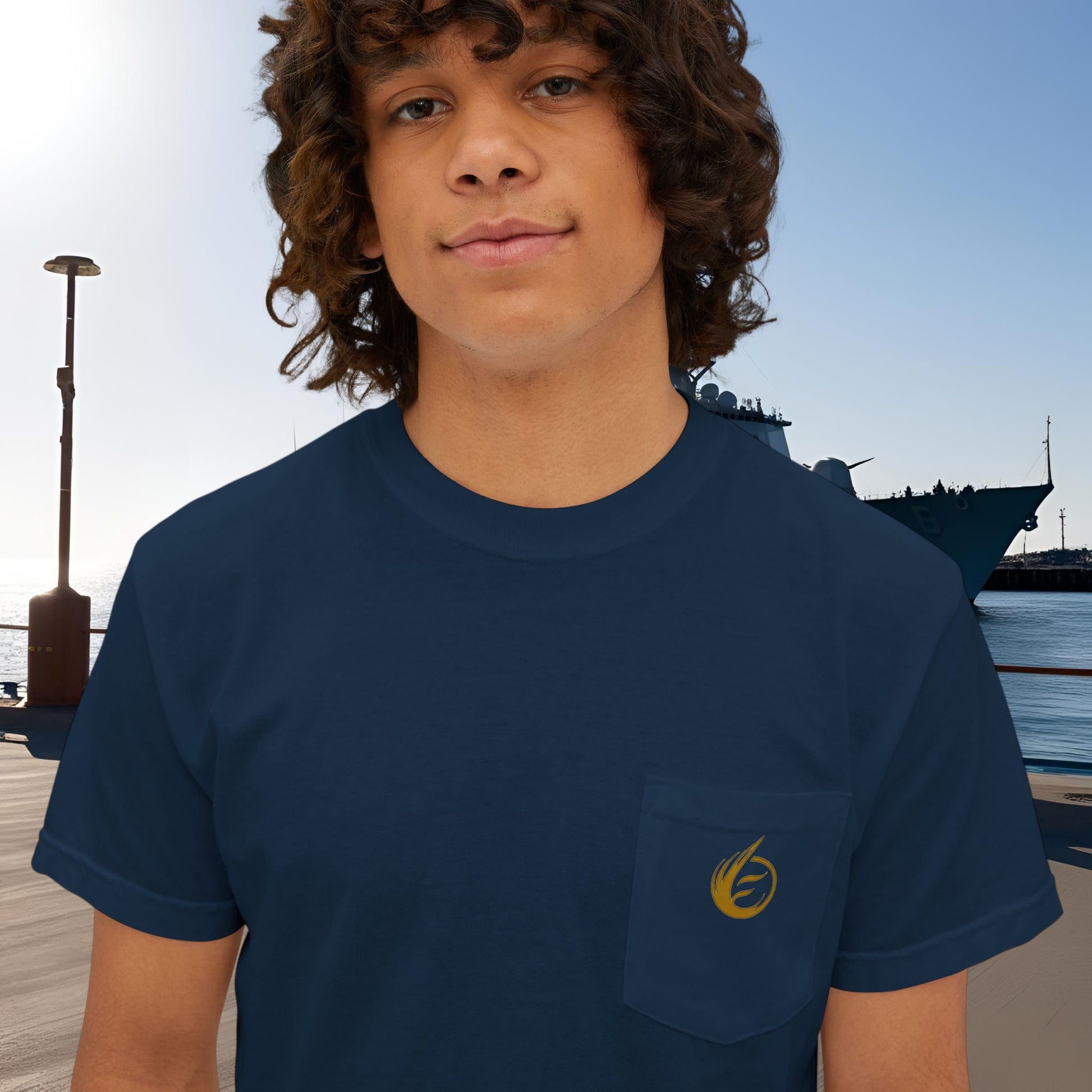 Person wearing a navy blue t-shirt with a yellow 'EssenceInnoCreate' logo on a dock background