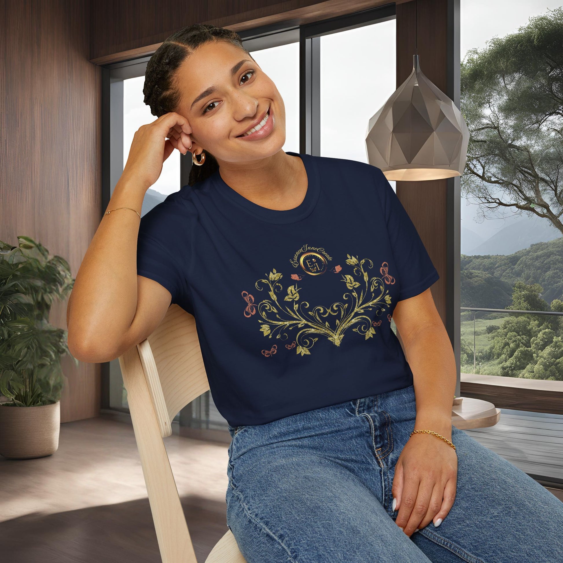 Woman wearing a navy blue t-shirt with Essence Innovation Bohemian Butterfly floral design sitting in a room with large windows.
