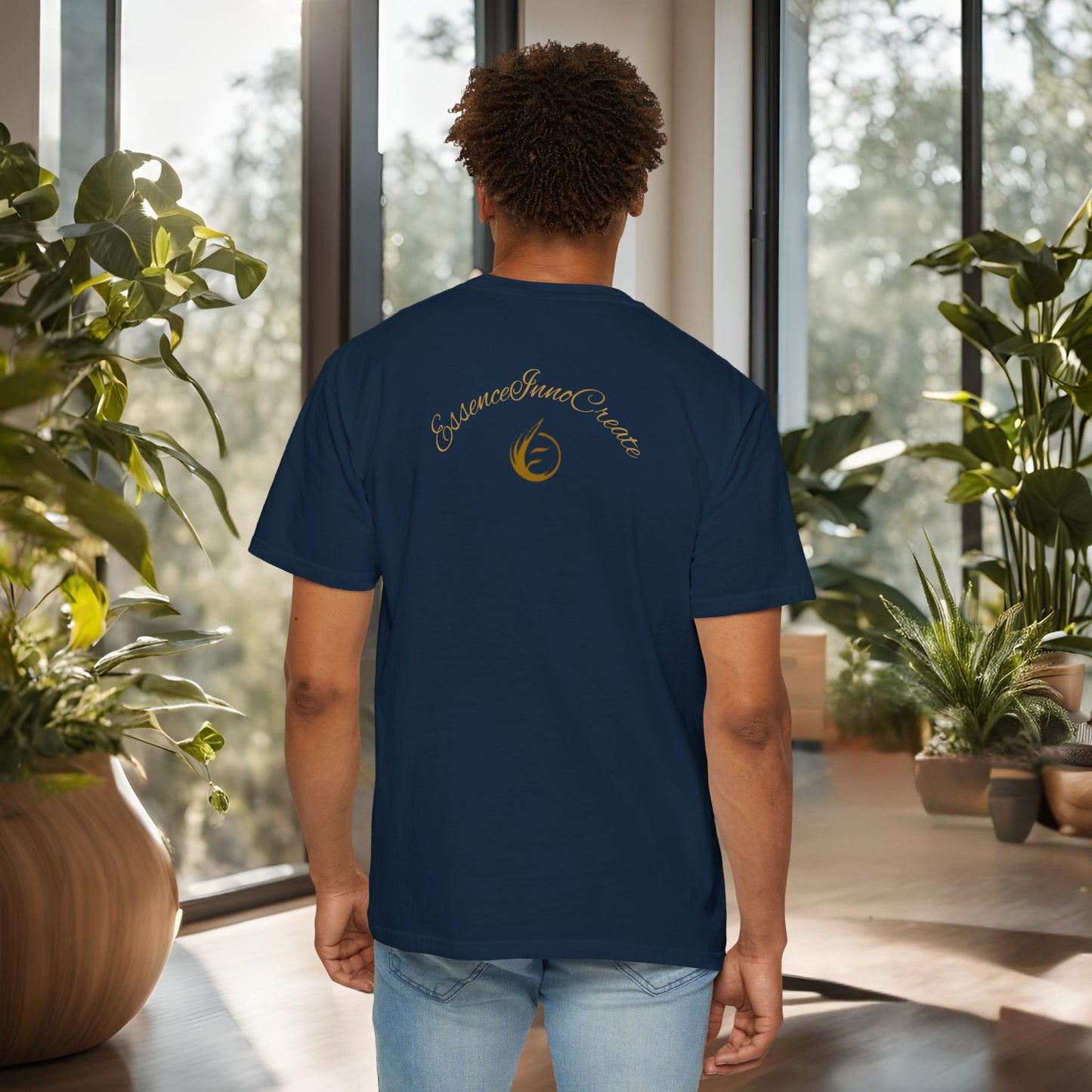 Person wearing a navy blue t-shirt with 'EssenceInnoCreate' logo in an indoor setting with plants