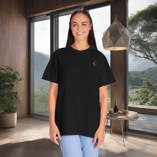 Person wearing a black t-shirt with a yellow 'EssenceInnoCreate' logo in a modern room with large windows.