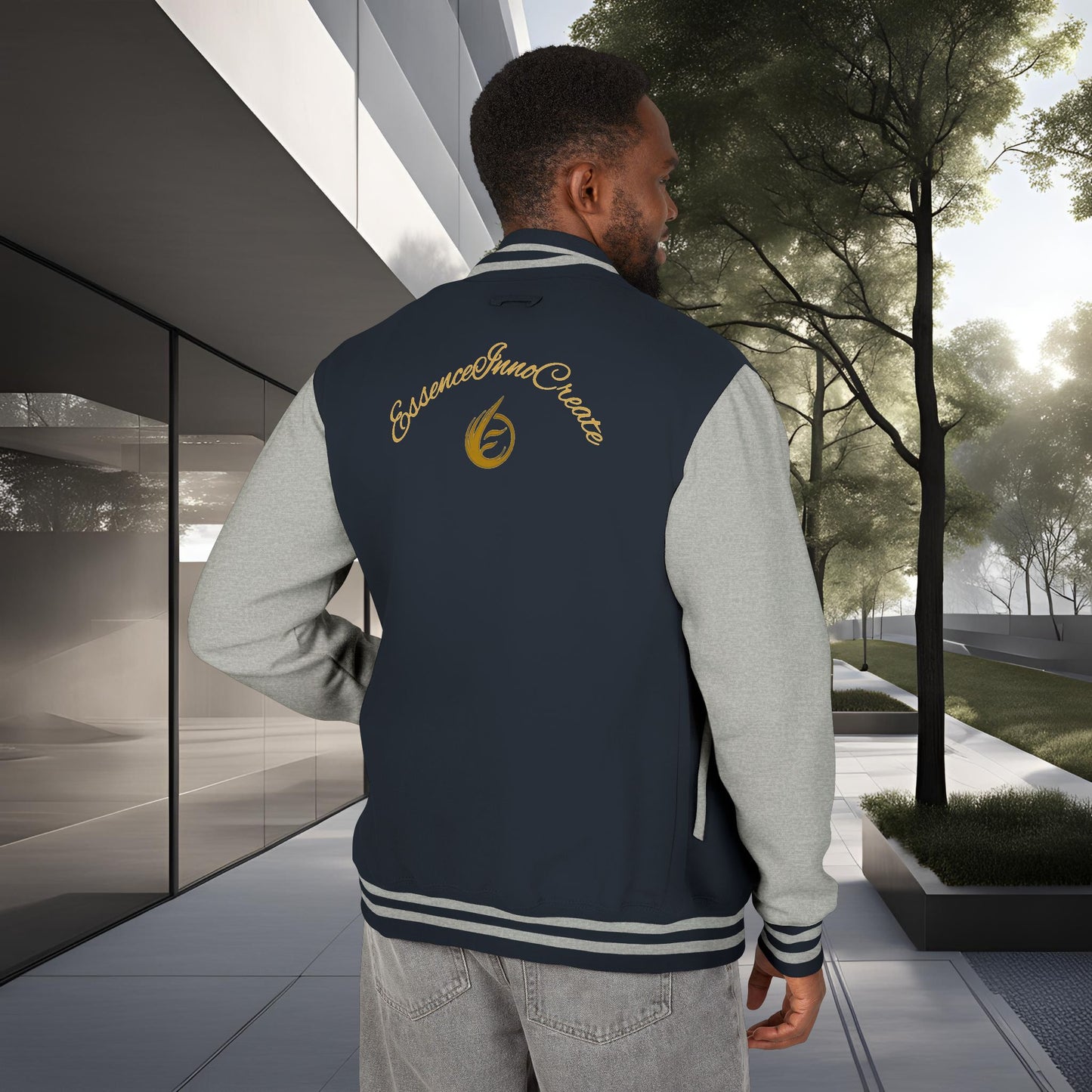 Man wearing a navy blue letterman jacket with a 'EssenceInnoCreate' logo, standing in an outdoor setting.