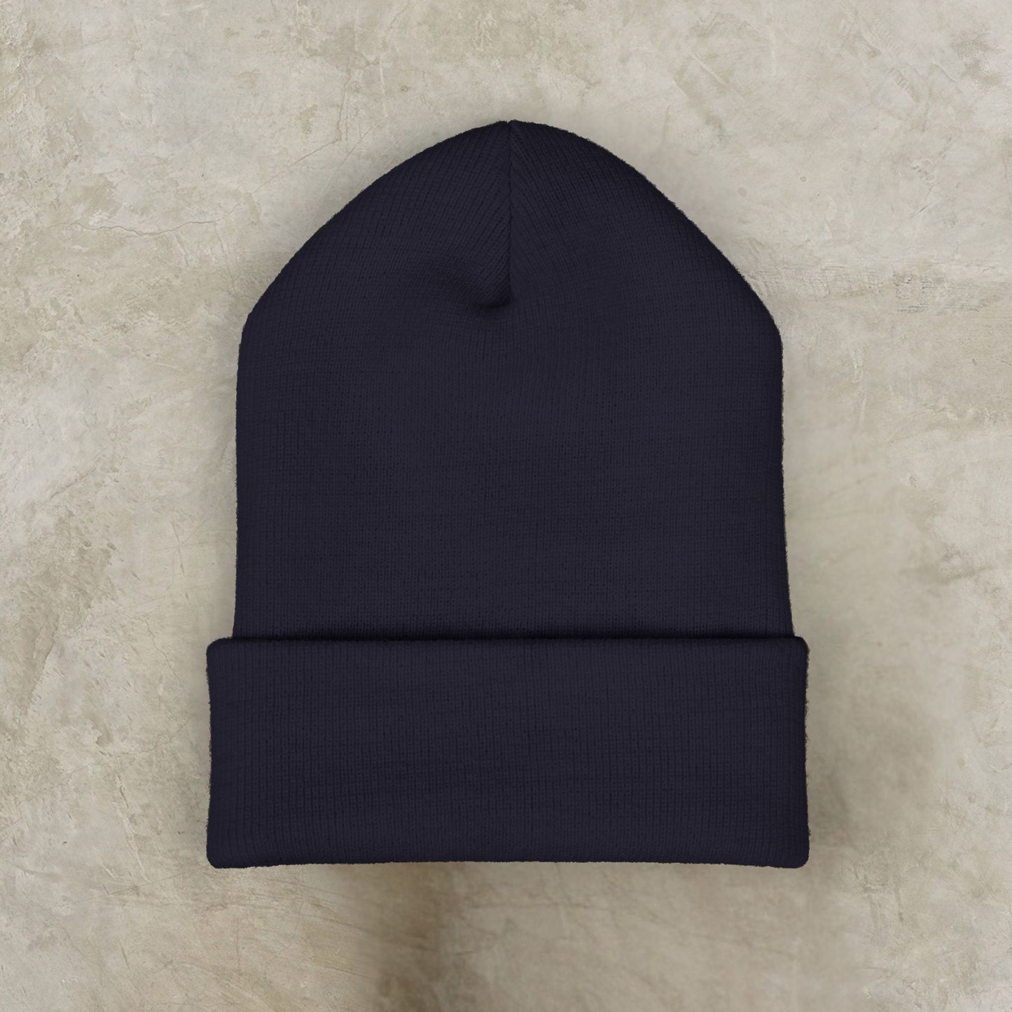 Black EssenceInnoCreate beanie on a beige textured surface