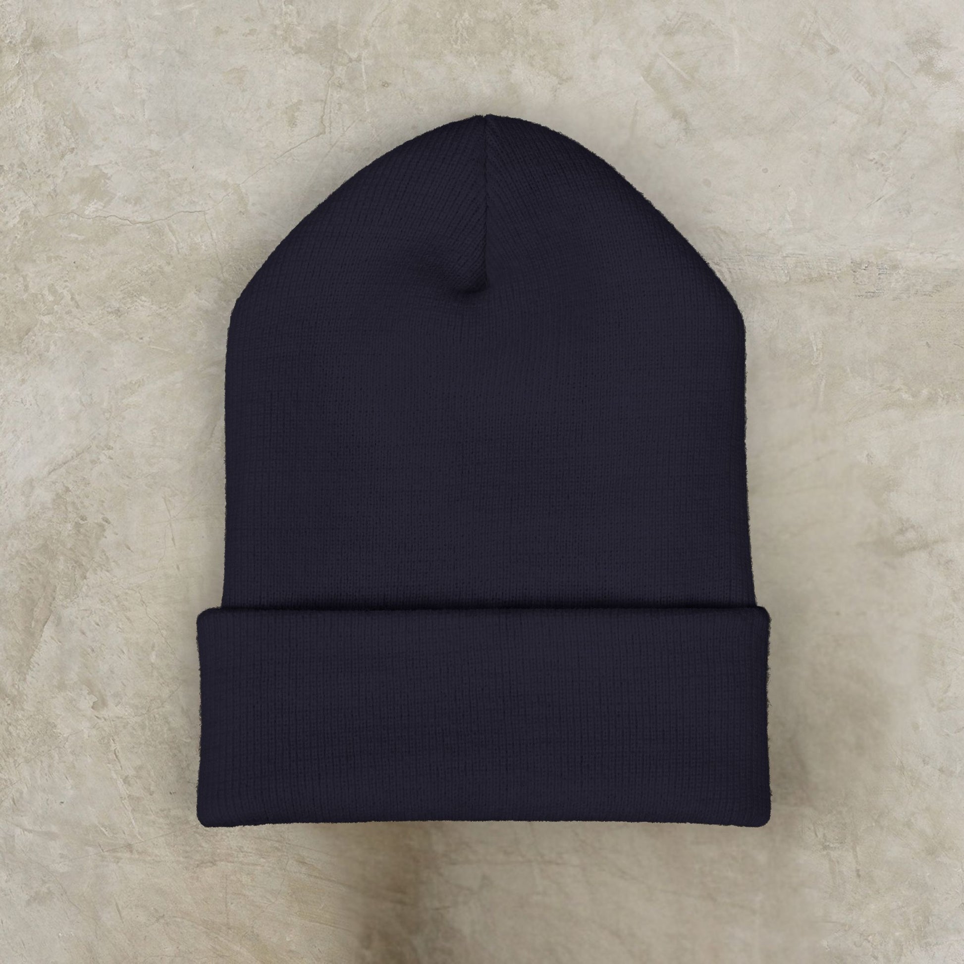 Black EssenceInnoCreate beanie on a beige textured surface