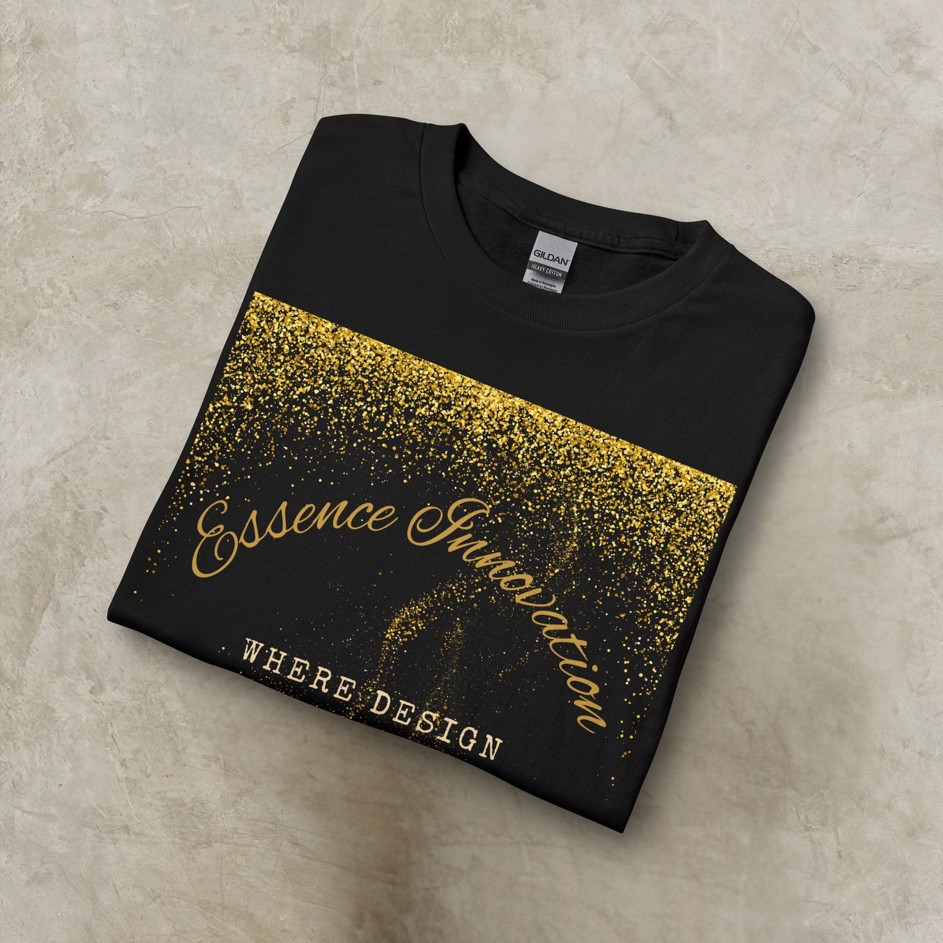 Folded black t-shirt with gold Essence Innovation 'Design Meets Soul' text on a beige surface
