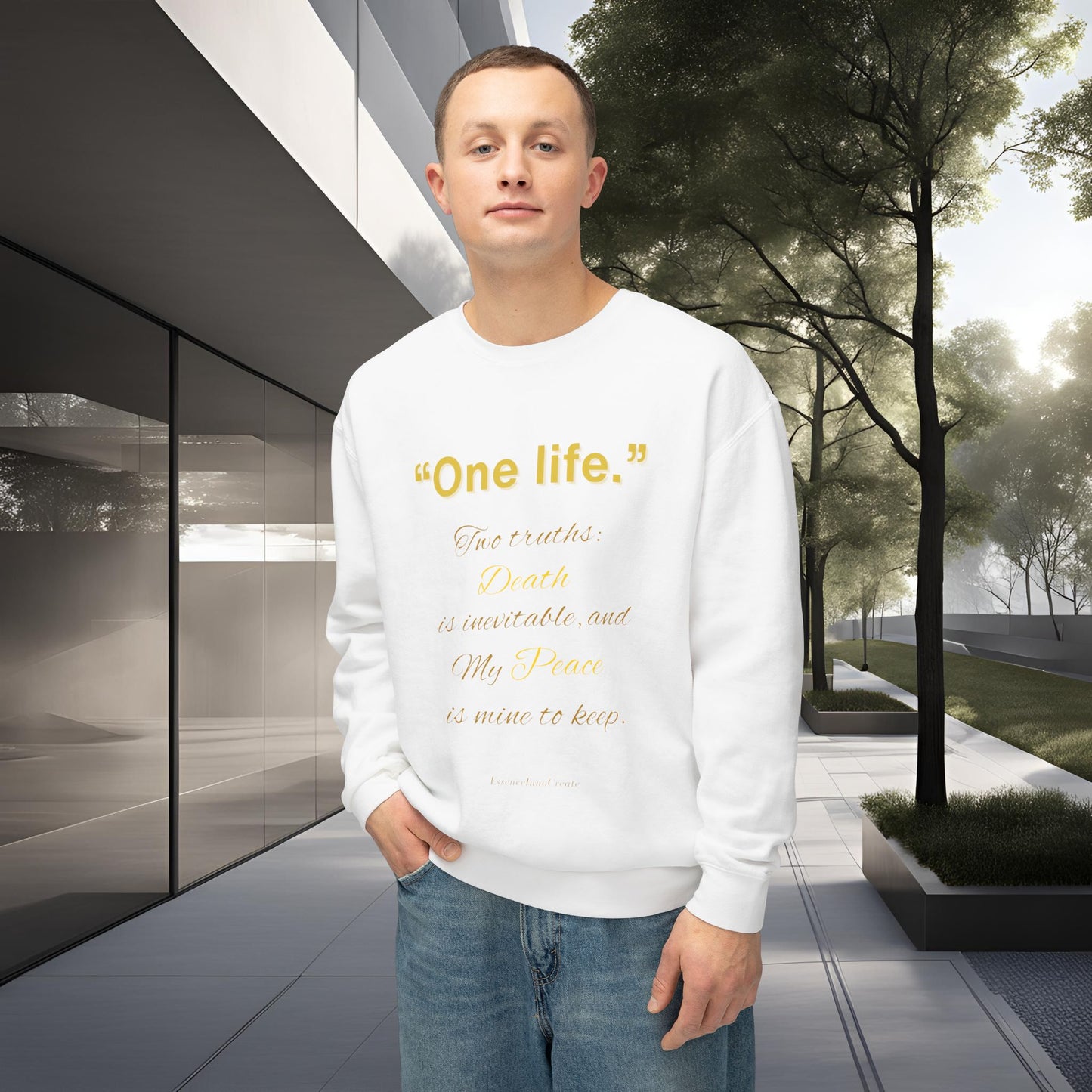 Person wearing a white sweatshirt with One Life text standing in front of modern architecture and trees.