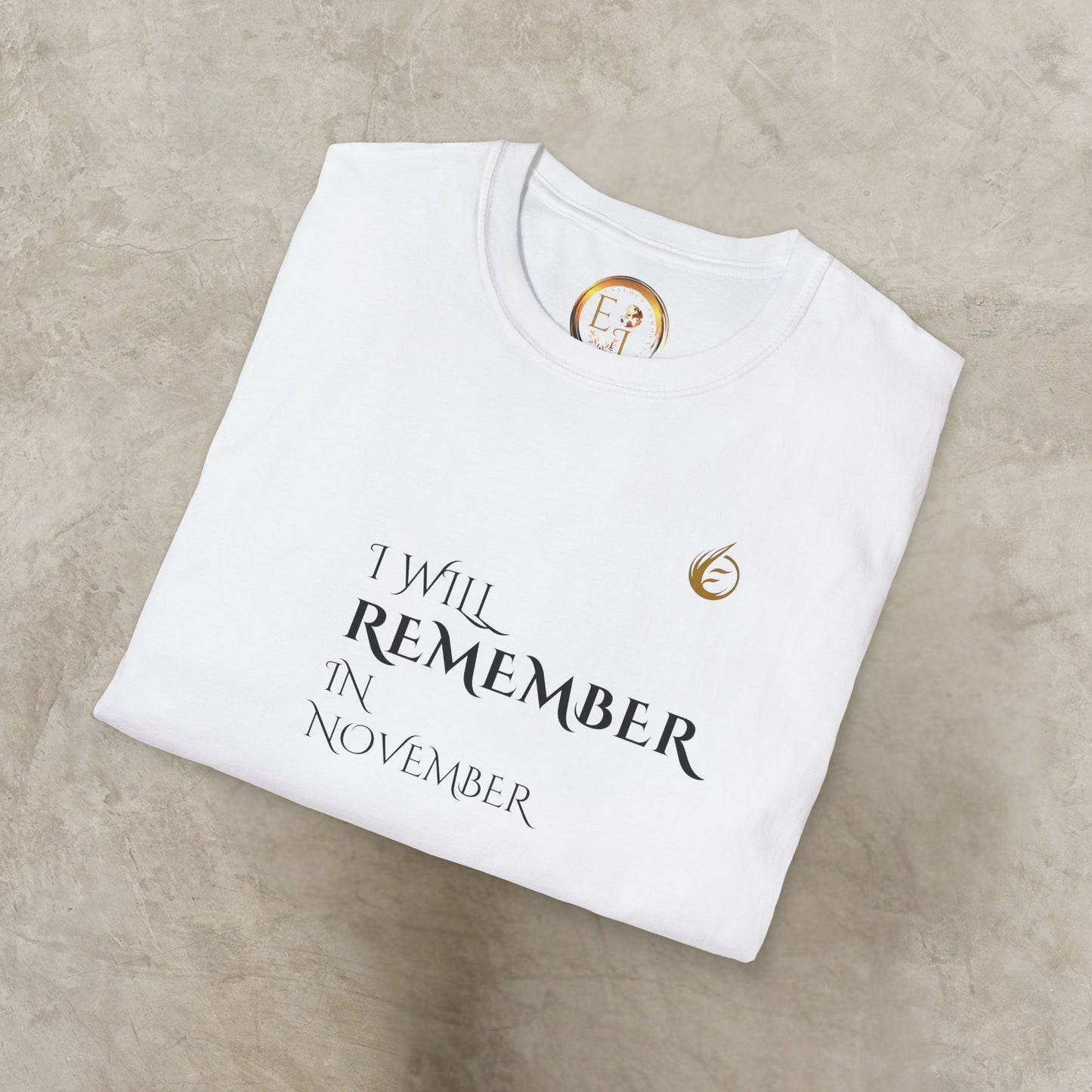 White EssenceInnoCreate Quiet Resolve t-shirt with 'I Will Remember In November' text on a beige surface