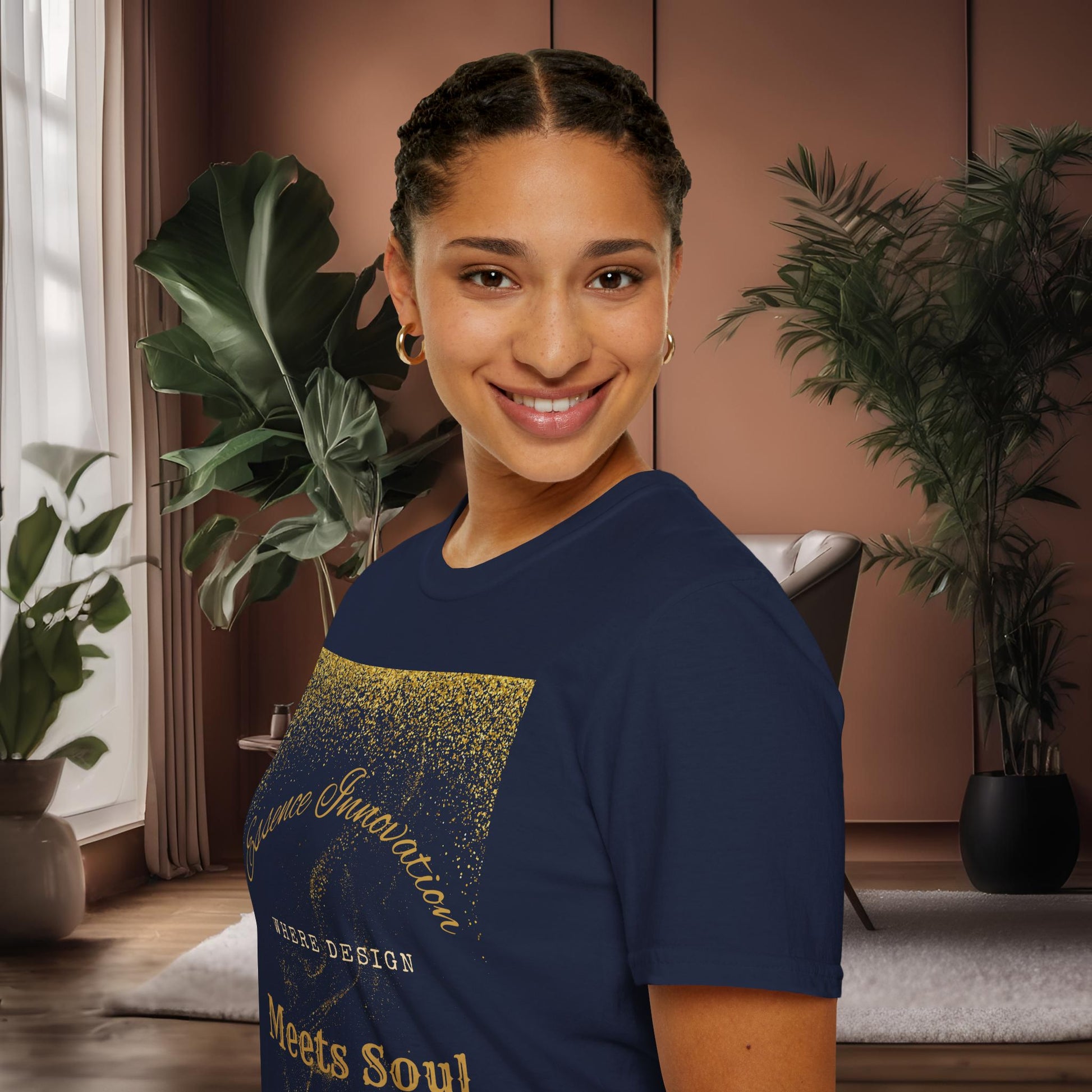 Woman wearing a navy blue t-shirt with gold Essence Innovation 'Design Meets Soul' text in a room with plants