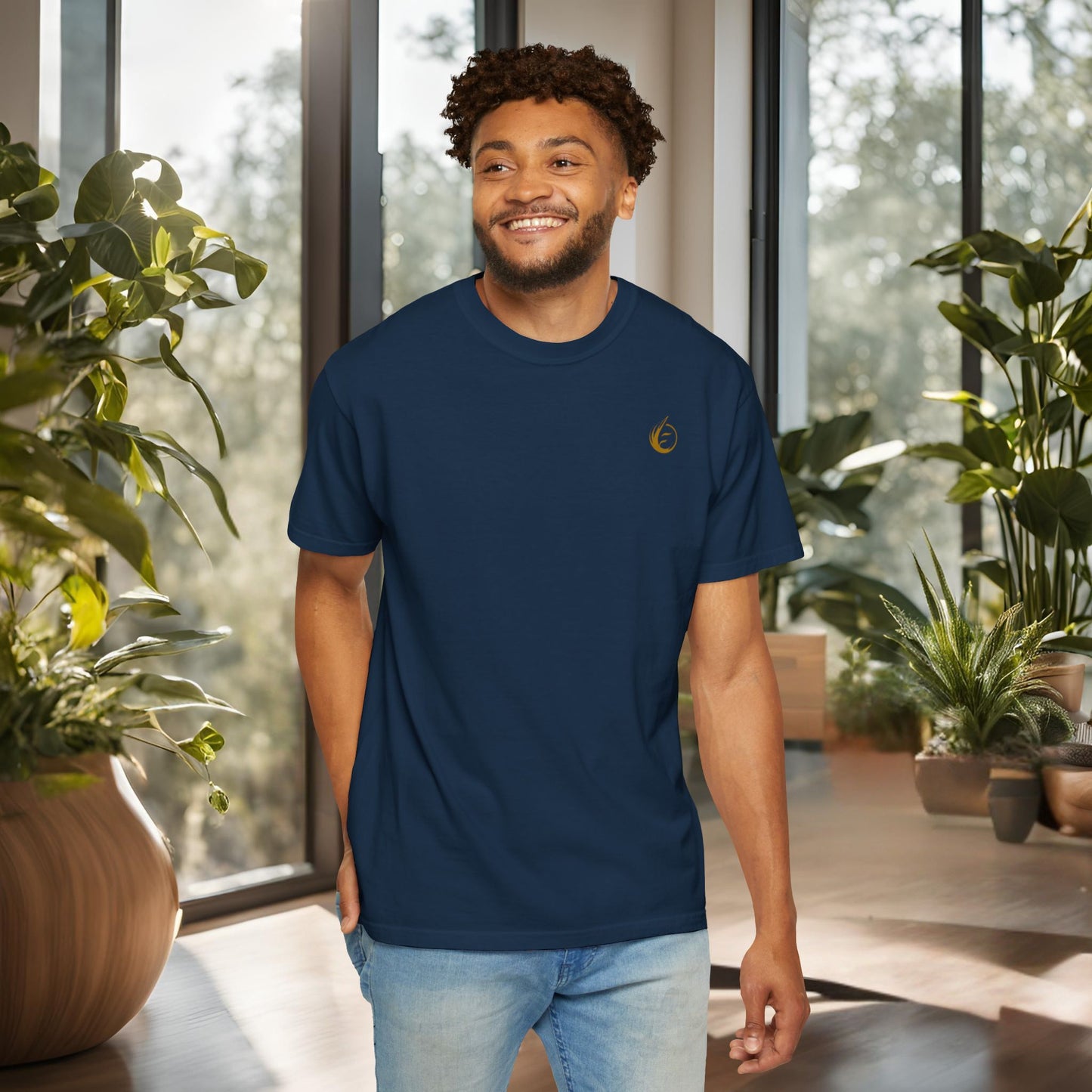 Man wearing a navy blue t-shirt with 'EssenceInnoCreate' logo indoors with plants