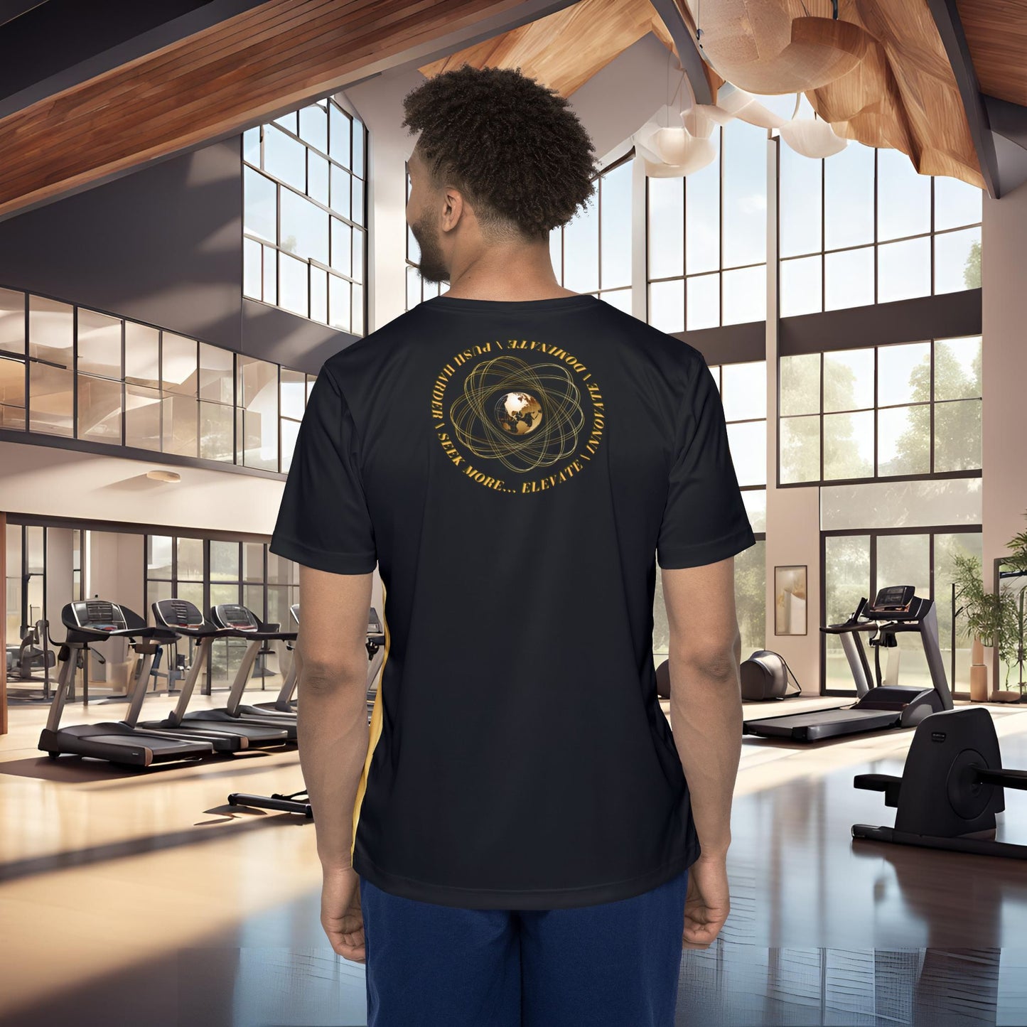 Man wearing a black t-shirt with gold Essence Innovation Seek More design in a gym setting