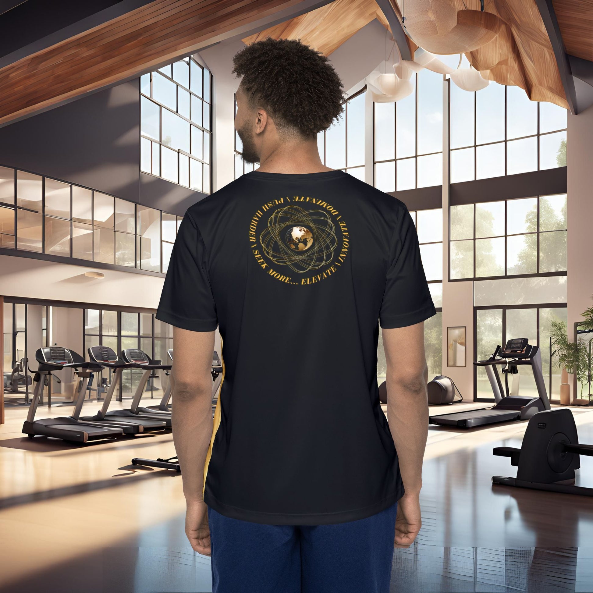 Man wearing a black t-shirt with gold Essence Innovation Seek More design in a gym setting