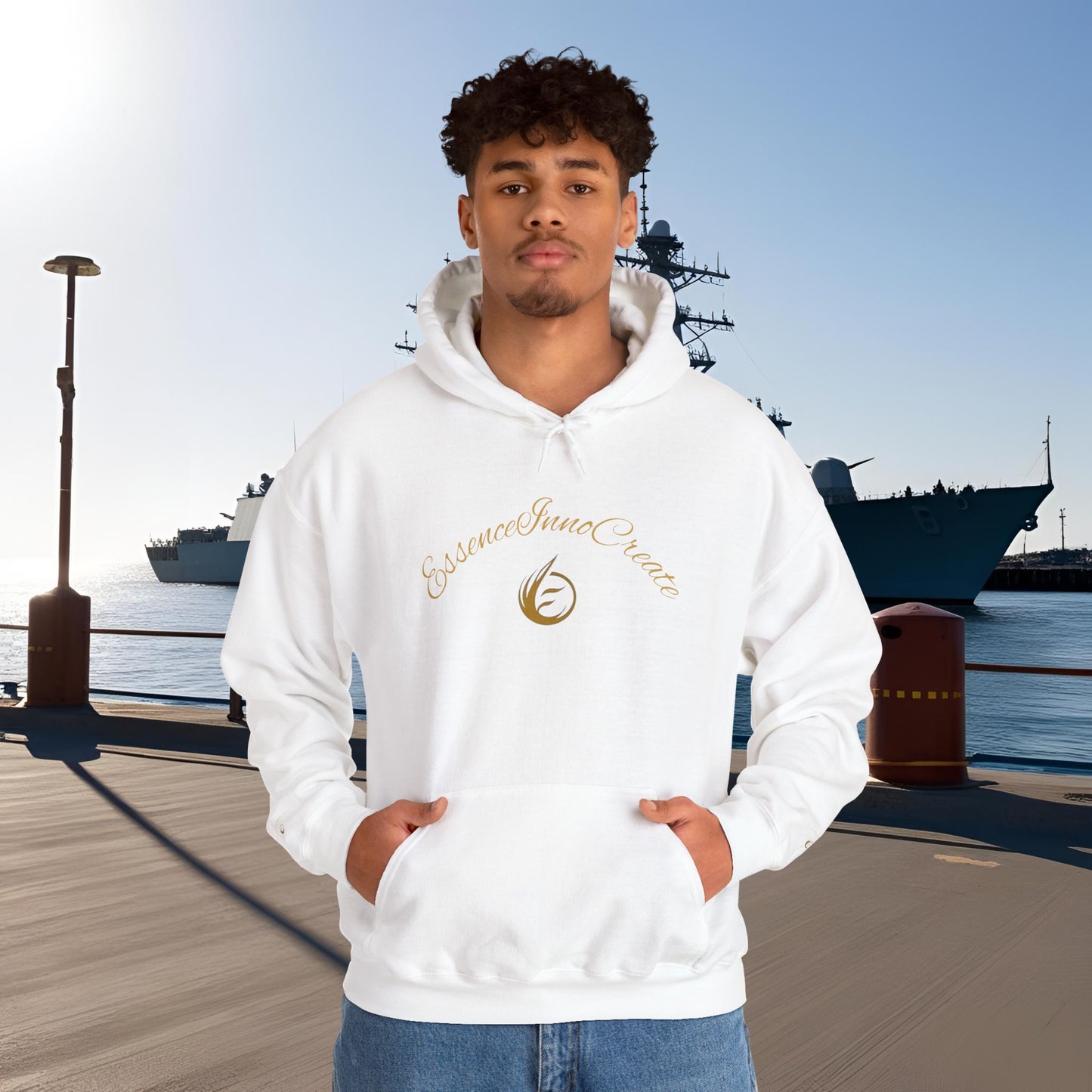 Person wearing a white hoodie with 'EssenceInnoCreate' logo and text, standing on a dock with ships in the background.