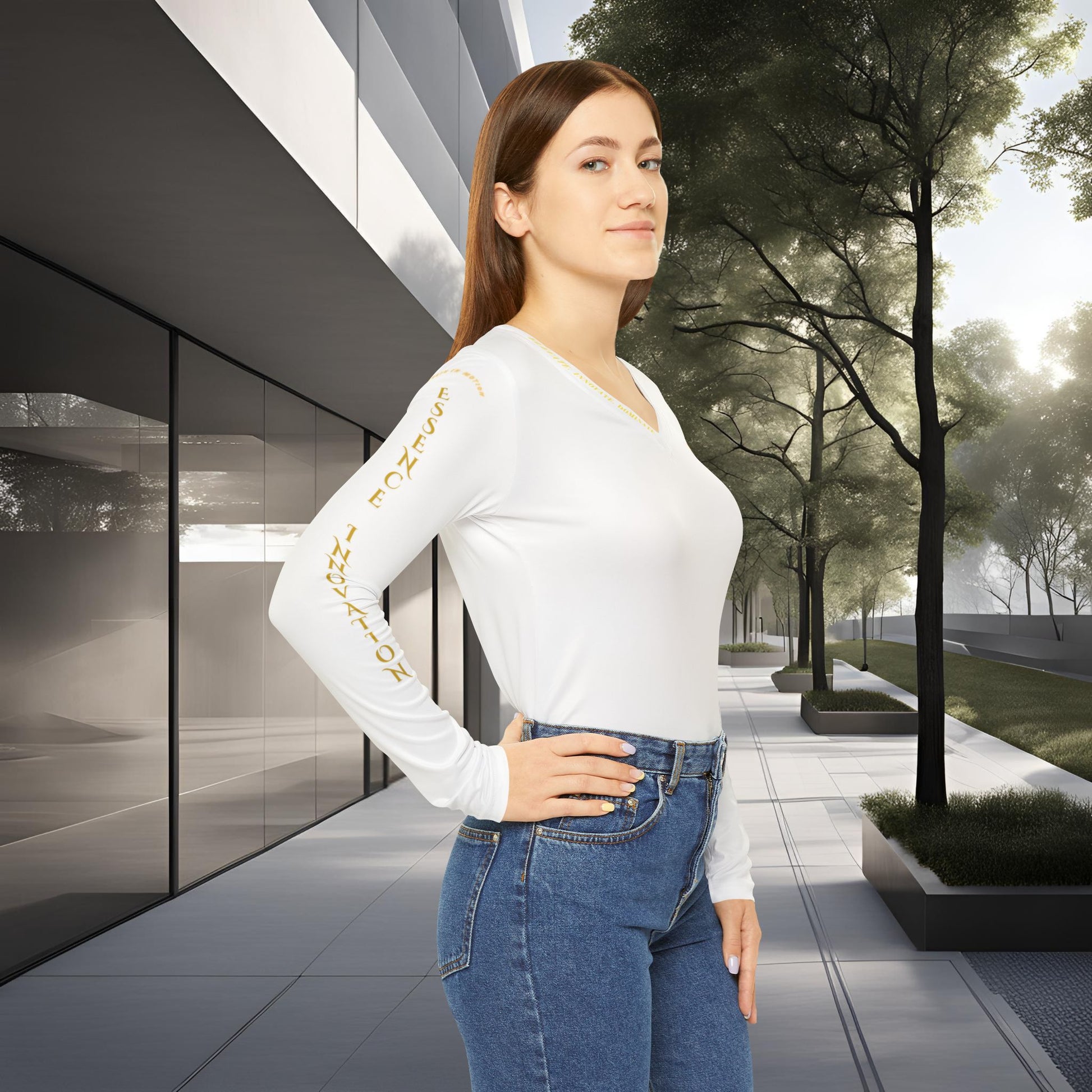 Woman wearing a white long-sleeve Essence Innovation Seek More shirt with text and blue jeans standing in an urban setting.
