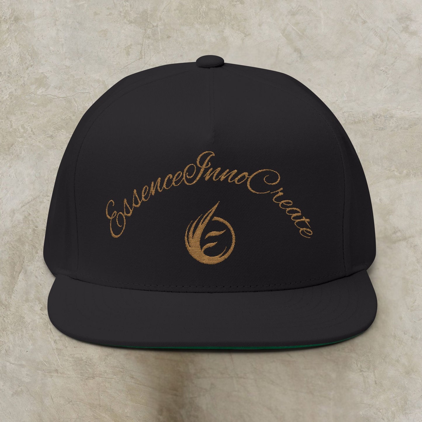 Black cap with gold EssenceInnoCreate text and logo on a beige background