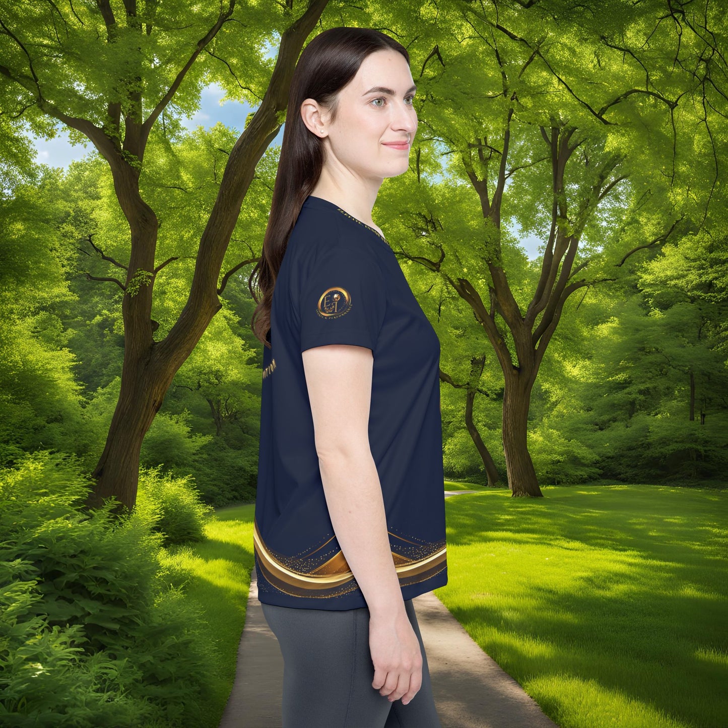 Woman wearing a navy blue shirt with a Essence Innovation logo in a park setting