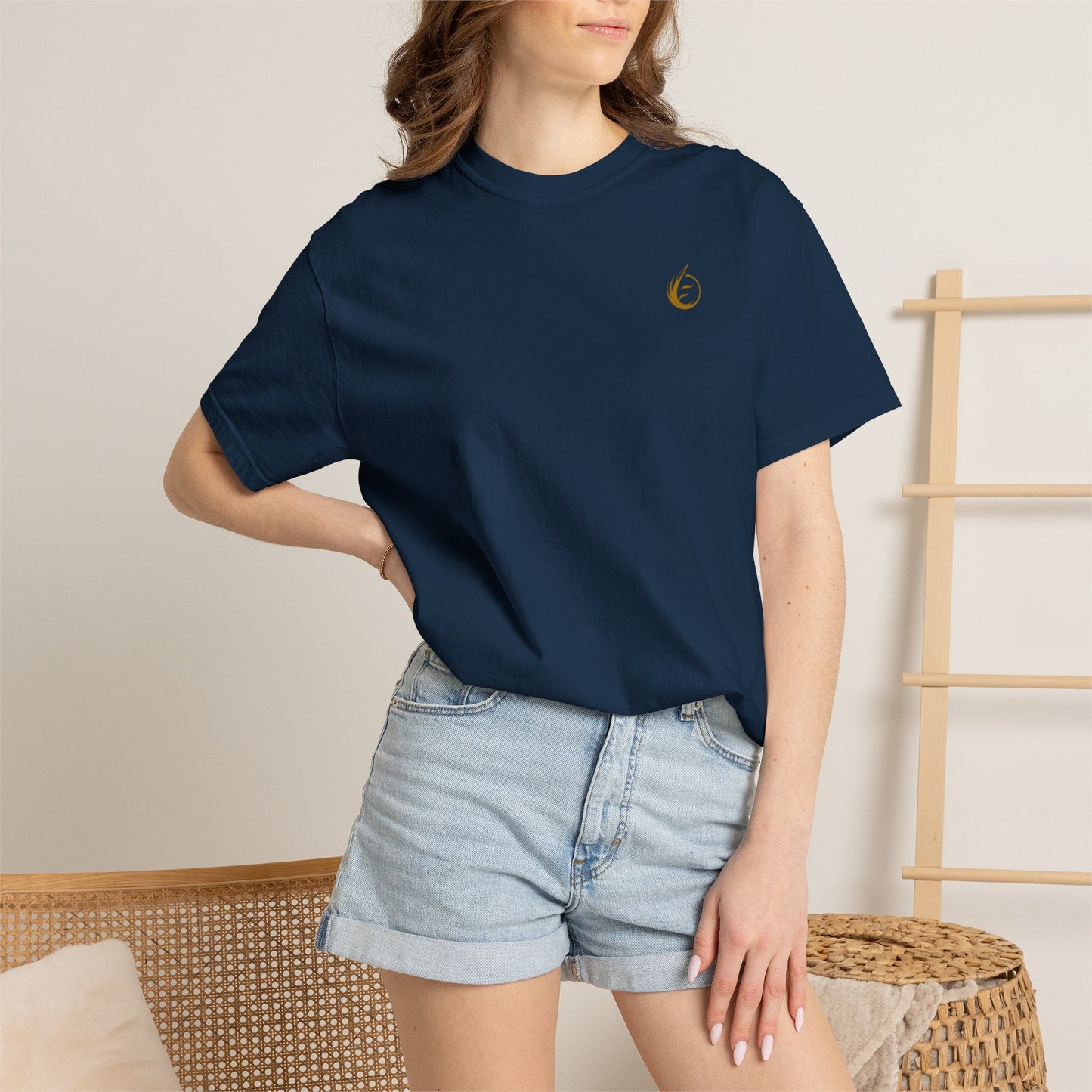 Person wearing a navy blue 'EssenceInnoCreate' t-shirt with a graphic design, standing against a neutral background.