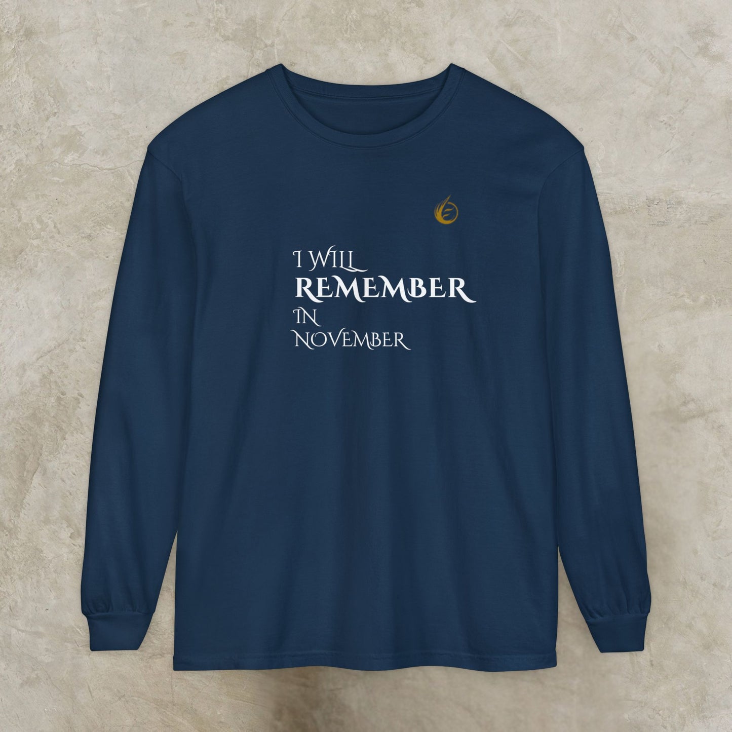 Navy blue long-sleeve EssenceInnoCreate Quiet Resolve shirt with text 'I Will Remember In November' on a beige background