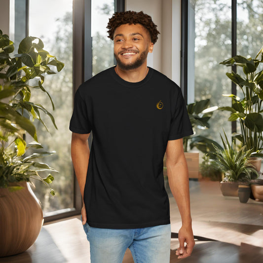 Man wearing a black t-shirt with a yellow 'EssenceInnoCreate' logo in a modern indoor setting with plants.
