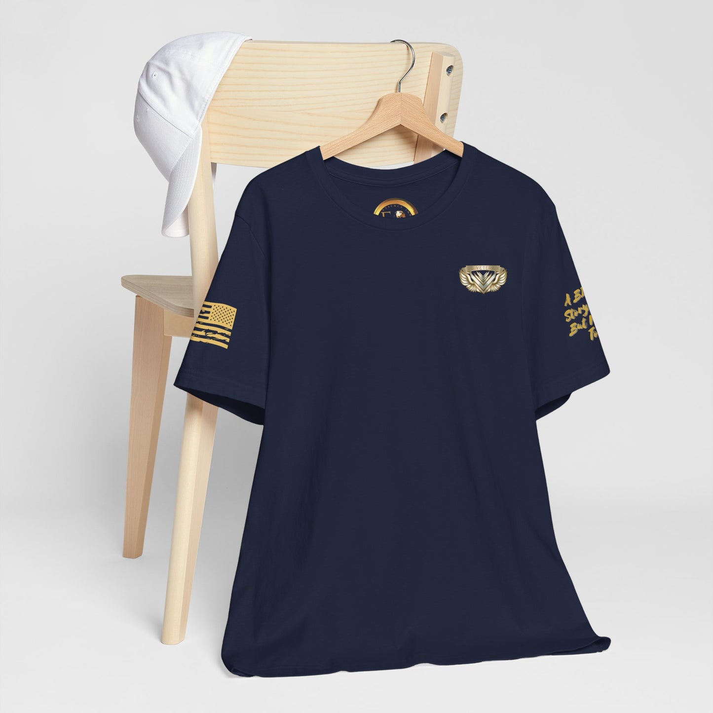 Black t-shirt with gold designs on a wooden chair against a white background