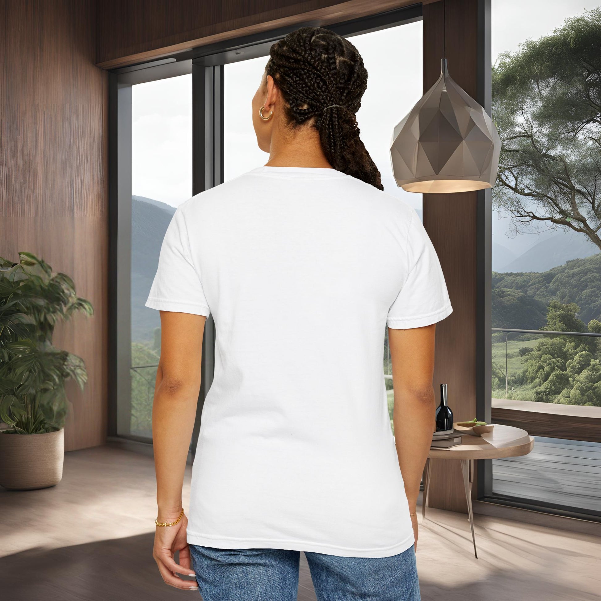 Person wearing a 'EssenceInnoCreate' white t-shirt in a modern room with large windows and a view of trees.