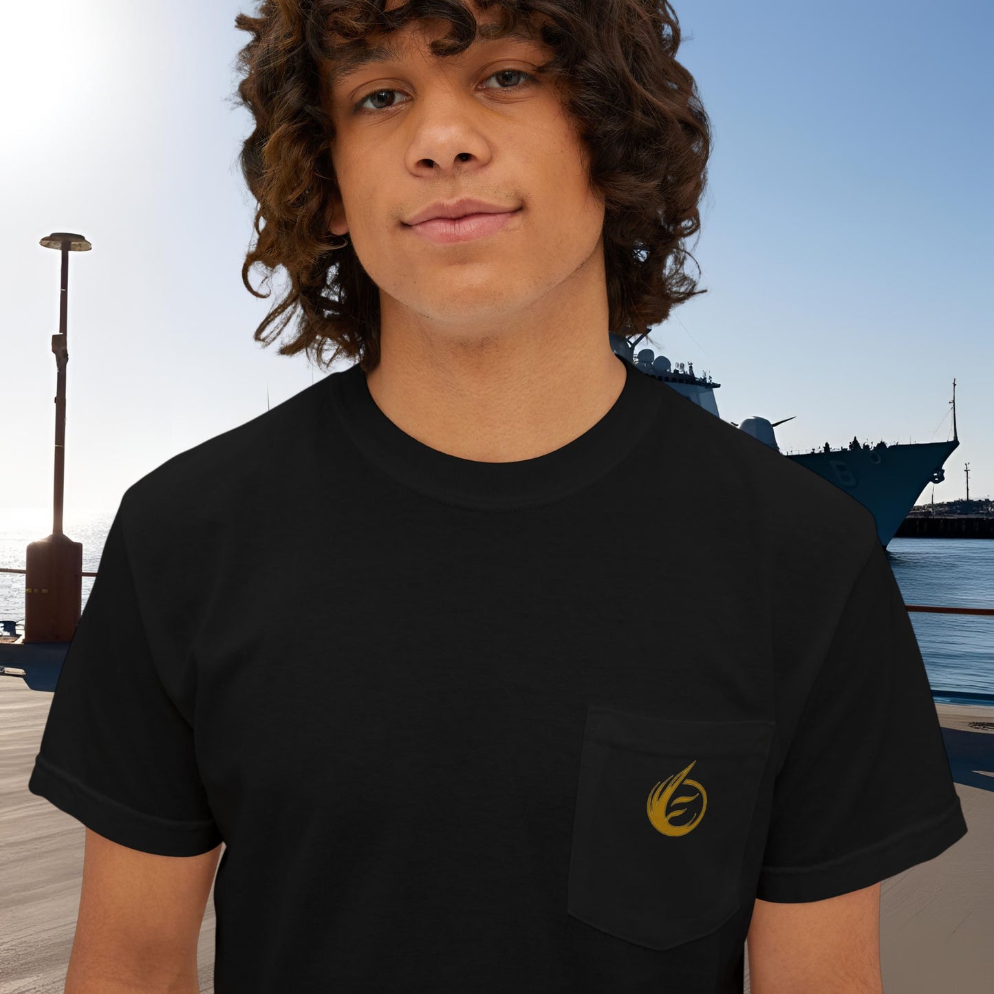 Person wearing a black t-shirt with 'EssenceInnoCreate' logo in front of a dock with boats.