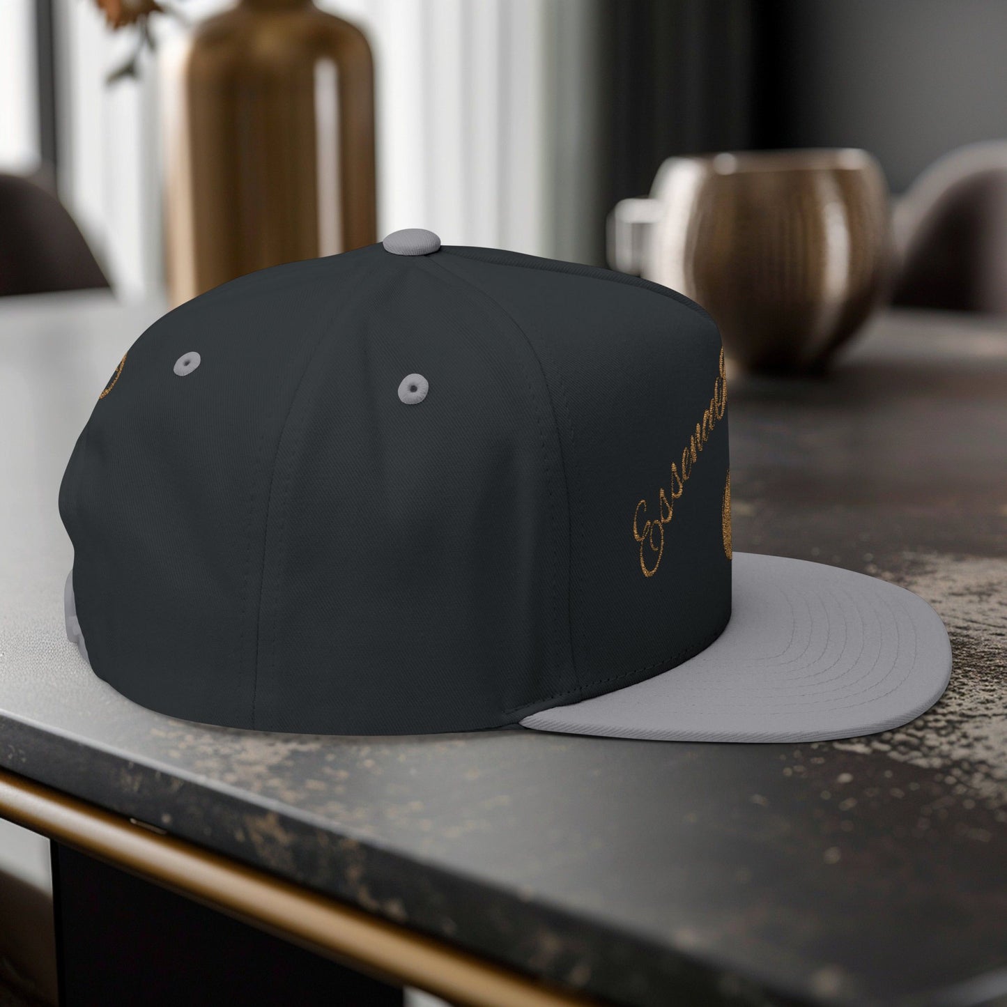 Black and gray cap with embroidered EssenceInnoCreate text on a table