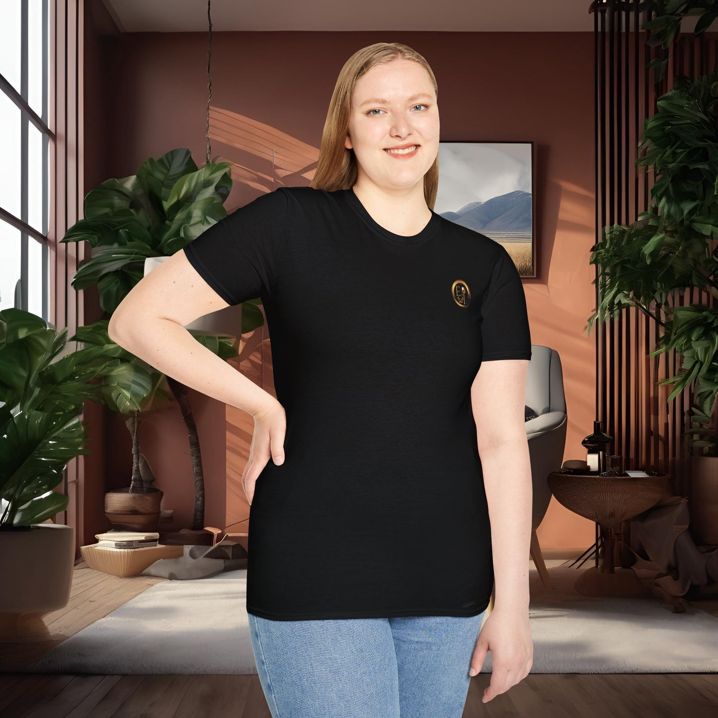 Person wearing a black t-shirt with an Essence Innovation logo in a room with plants and decor