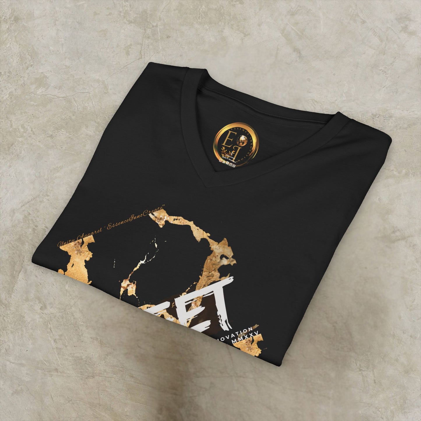 Black EssenceInnoCreate t-shirt with gold and white design on a textured surface