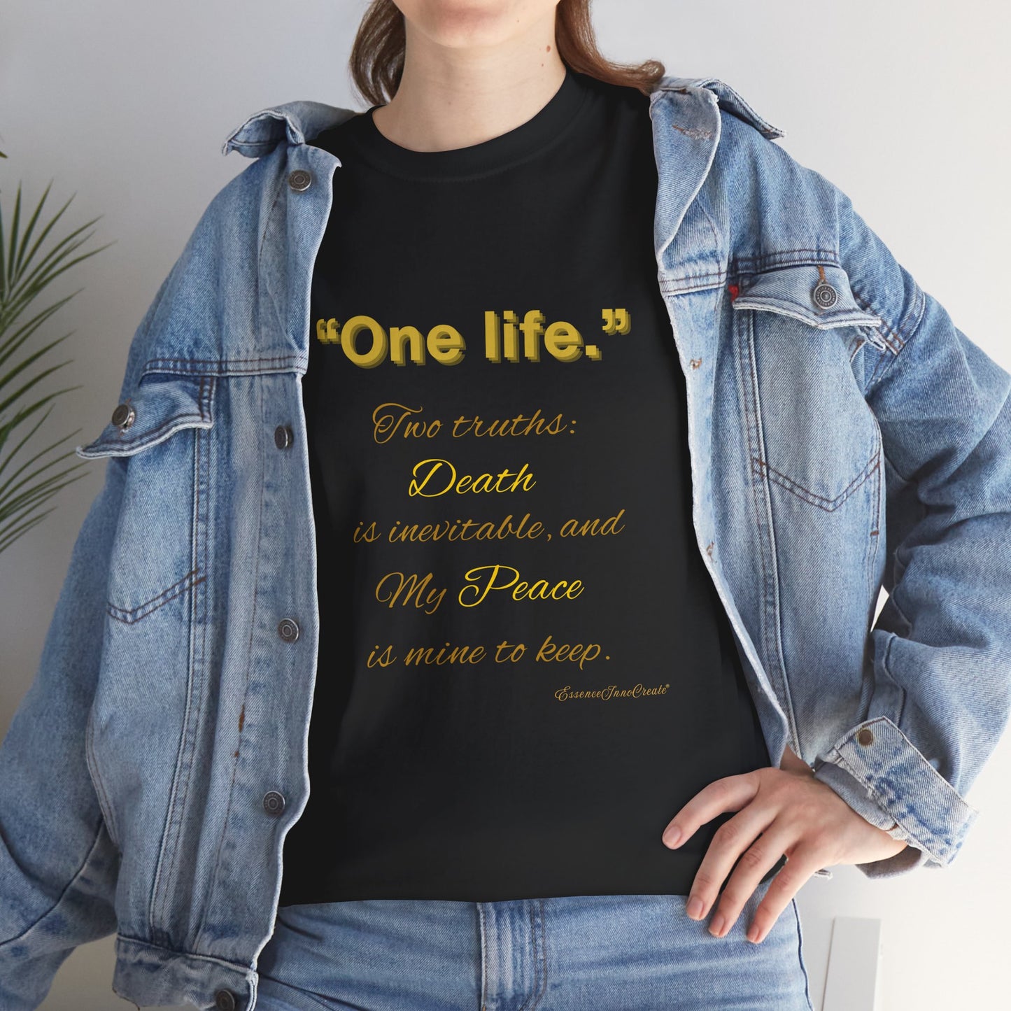 Person wearing a black t-shirt with yellow One Life text and a denim jacket.