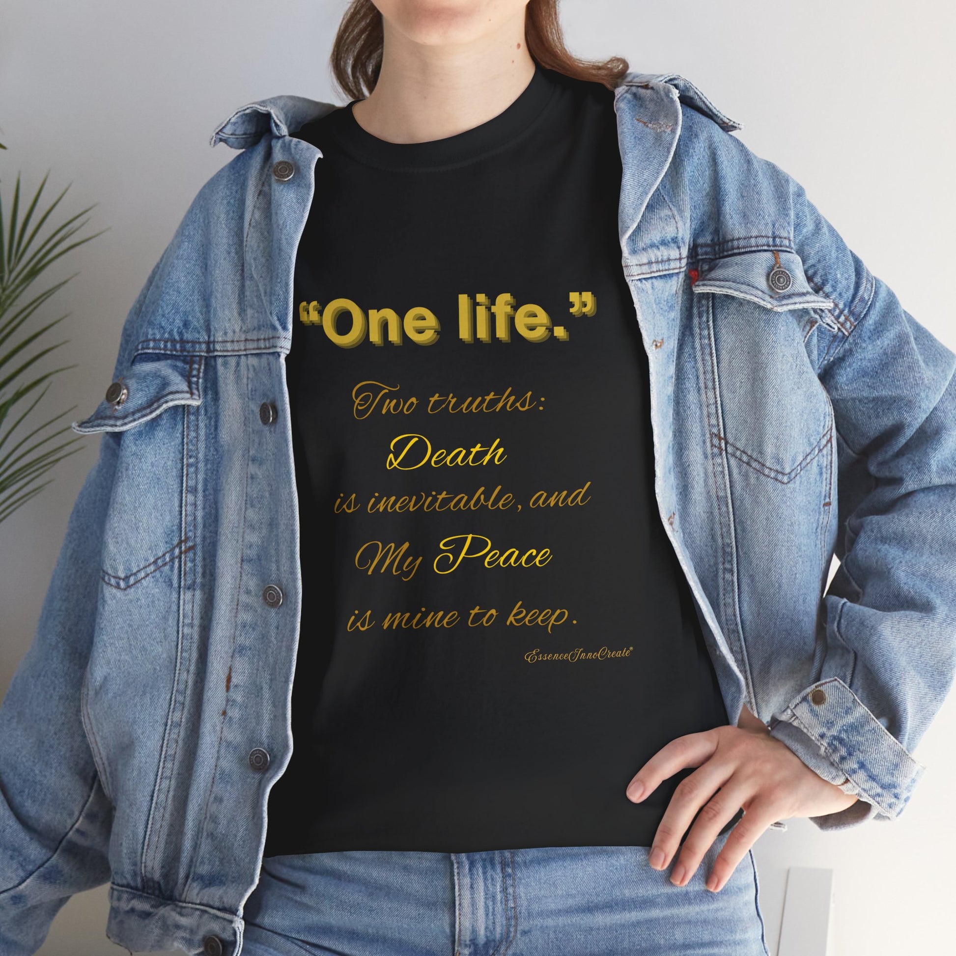 Person wearing a black t-shirt with yellow One Life text and a denim jacket.
