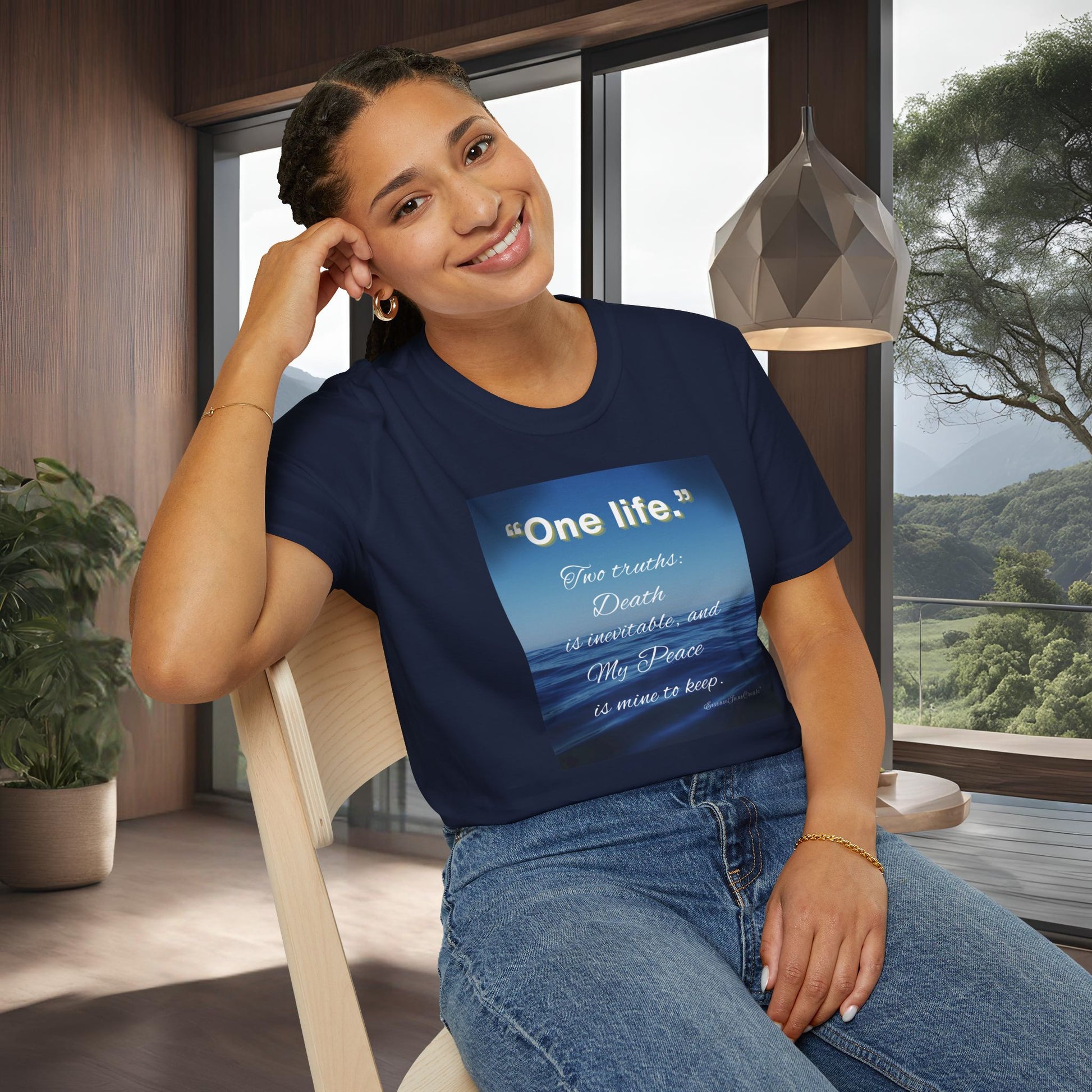 Woman wearing a navy blue 'One Life' t-shirt with a quote design, sitting indoors.