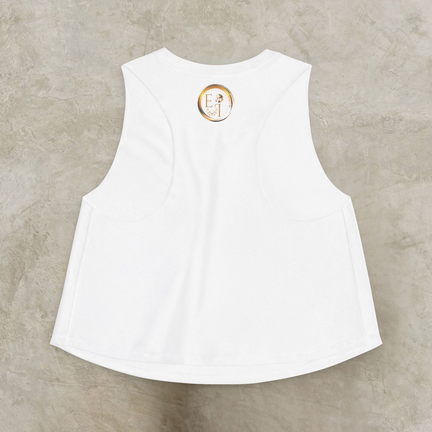 White sleeveless Essence Innovation Bohemian Butterfly top with a logo on the back against a beige background