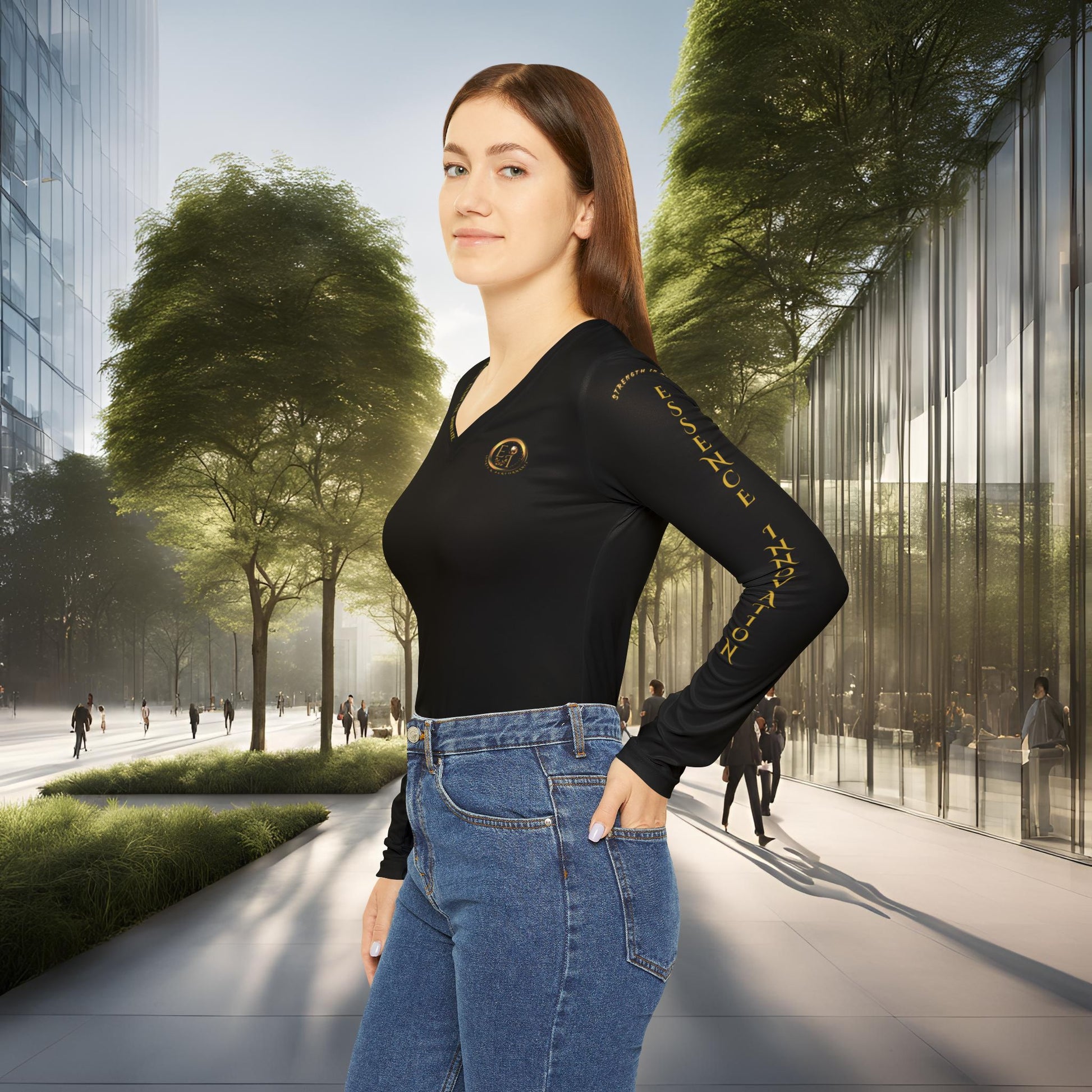 Woman in a black Essence Innovation Seek More long-sleeve top and blue jeans standing in an urban setting with trees and modern buildings.