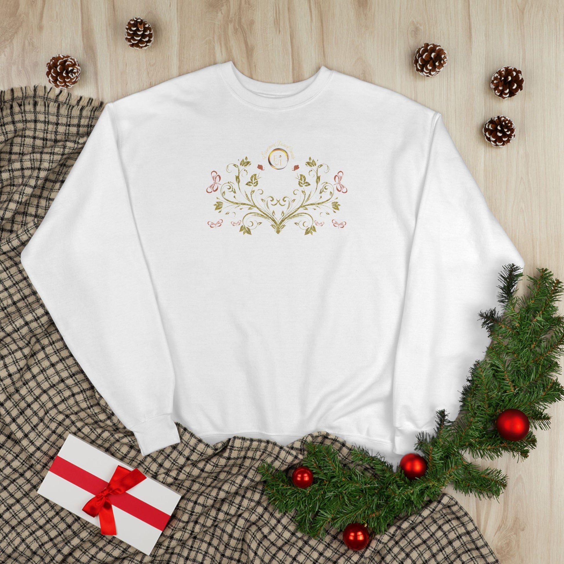 White sweatshirt with decorative Essence Innovation Bohemian Butterfly Crest design on a wooden surface with Christmas decorations.