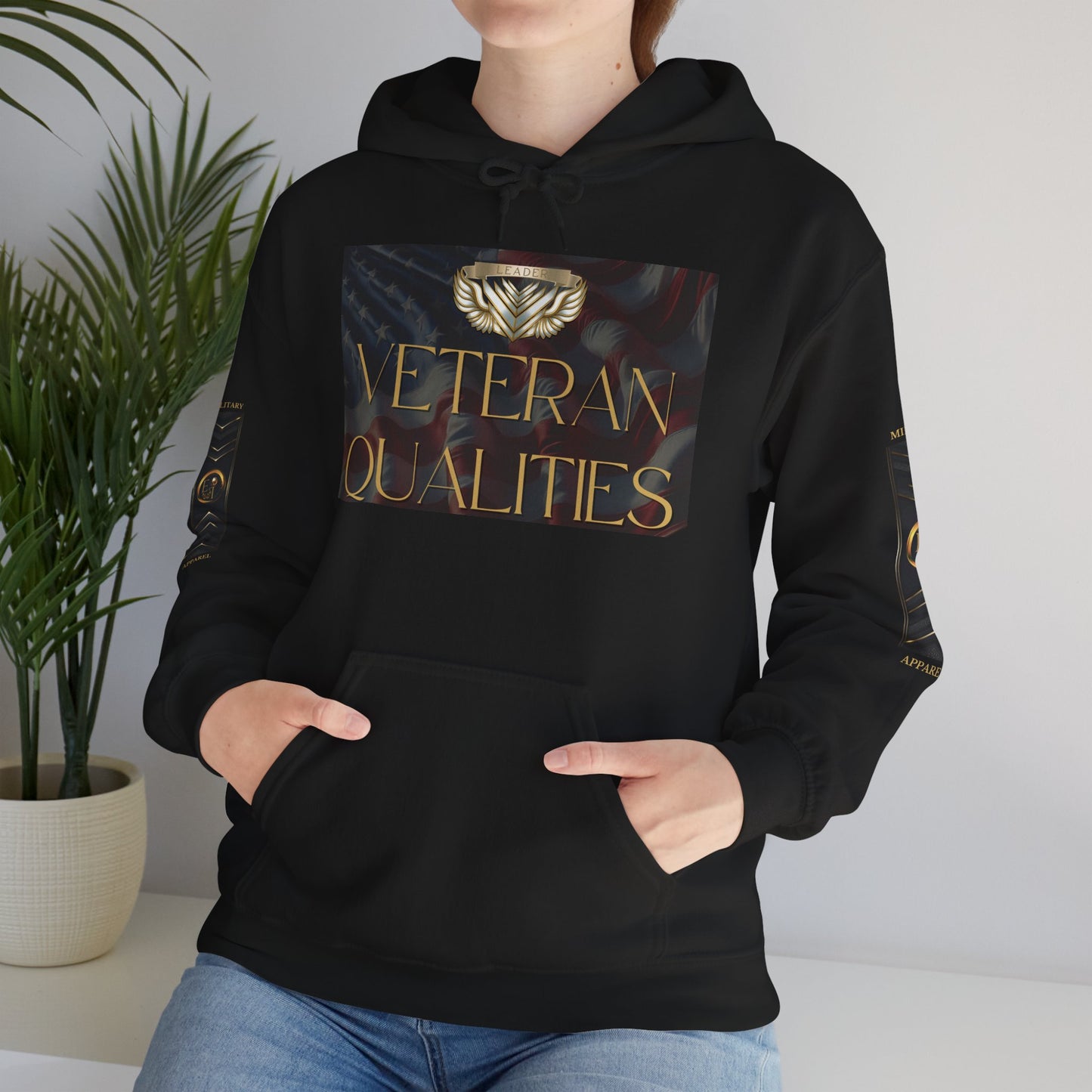 Person wearing a black Essence Innovation hoodie with a military design, standing against a neutral background.