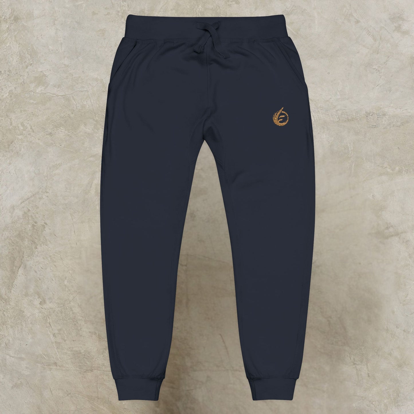 Dark blue 'EssenceInnoCreate' Quiet Resolve jogger pants with a logo on a beige background