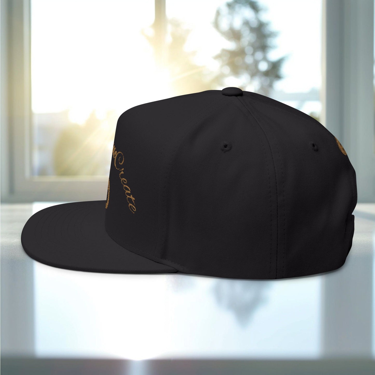 Black cap with gold EssenceInnoCreate text on a white surface with a blurred background