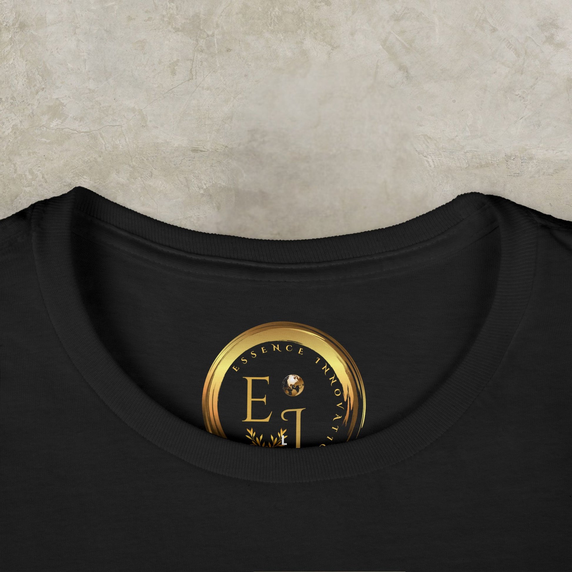 Black t-shirt with a gold and black Essence Innovation logo on a textured beige background