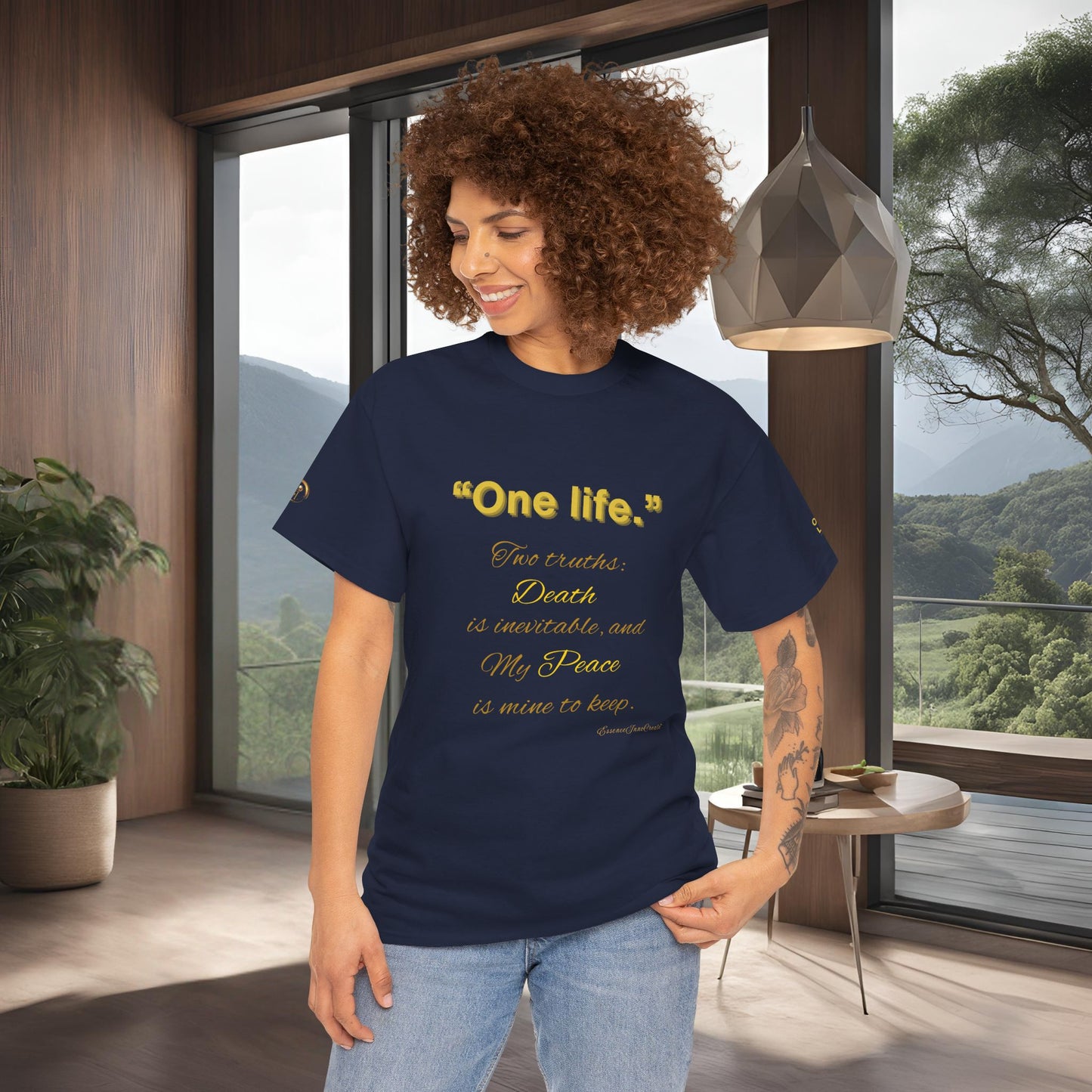 Woman wearing a black t-shirt with yellow Essence Innovation One Life text in a modern room with large windows.