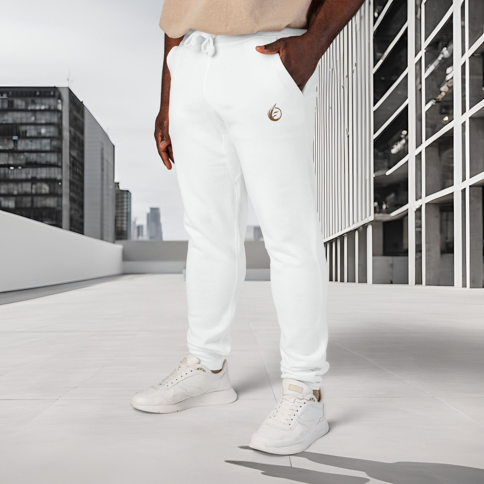 Person wearing white 'EssenceInnoCreate' Quiet Resolve jogger pants and white sneakers on a rooftop with cityscape background