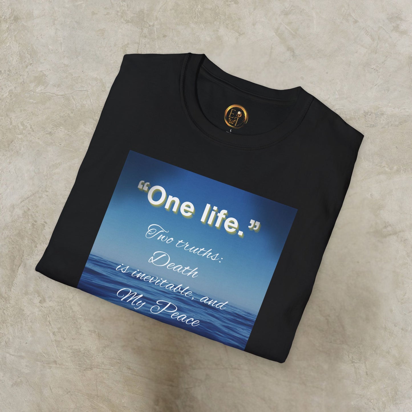 Black 'One Life' t-shirt with a blue graphic and text on a beige surface